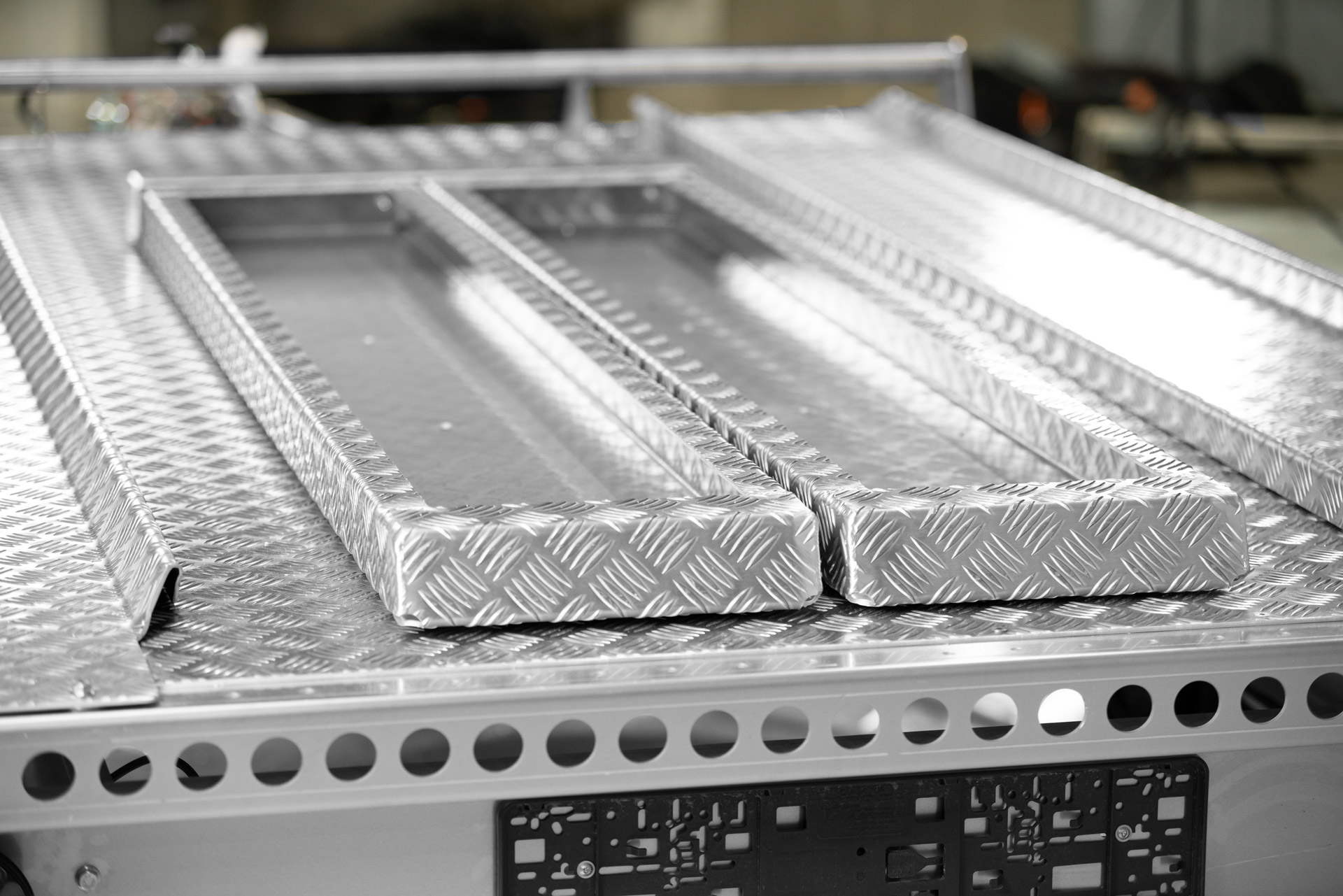 Anhänger mit zwei Auffahrrampen in einer Aluminiumhalterung auf der Plattform befestigt