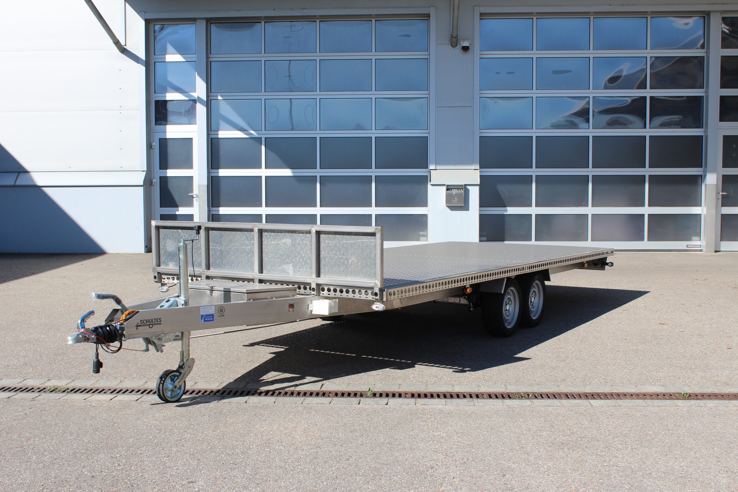Edelstahl Anhänger 5,10m x 2,10m mit Aluminium Bodenplatte und Stirnwand. Silber, 2-Achser vor einer Halle auf einem Hof