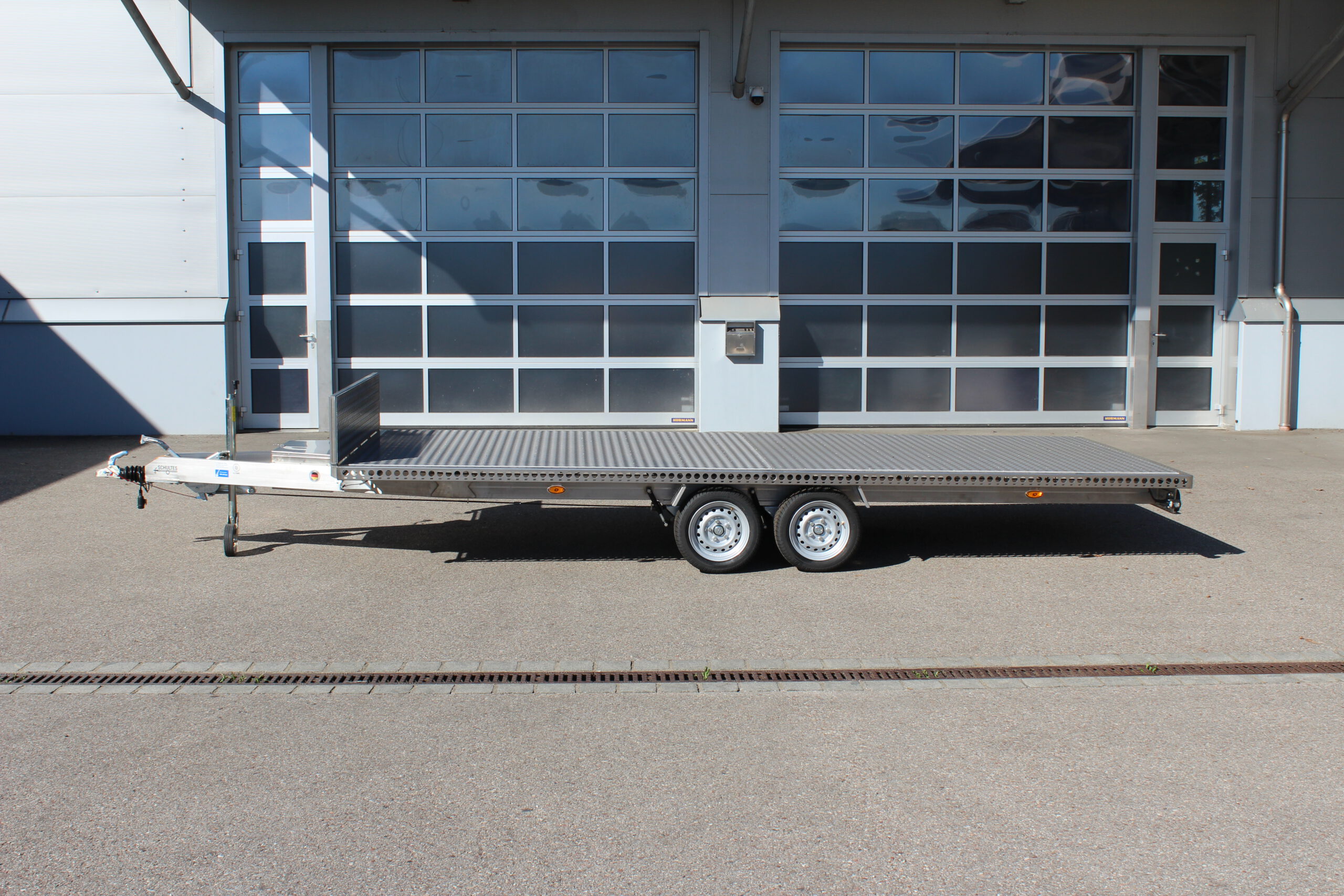 Edelstahl Anhänger 5,10m x 2,10m mit Aluminium Bodenplatte und Stirnwand. Silber, 2-Achser vor einer Halle auf einem Hof
