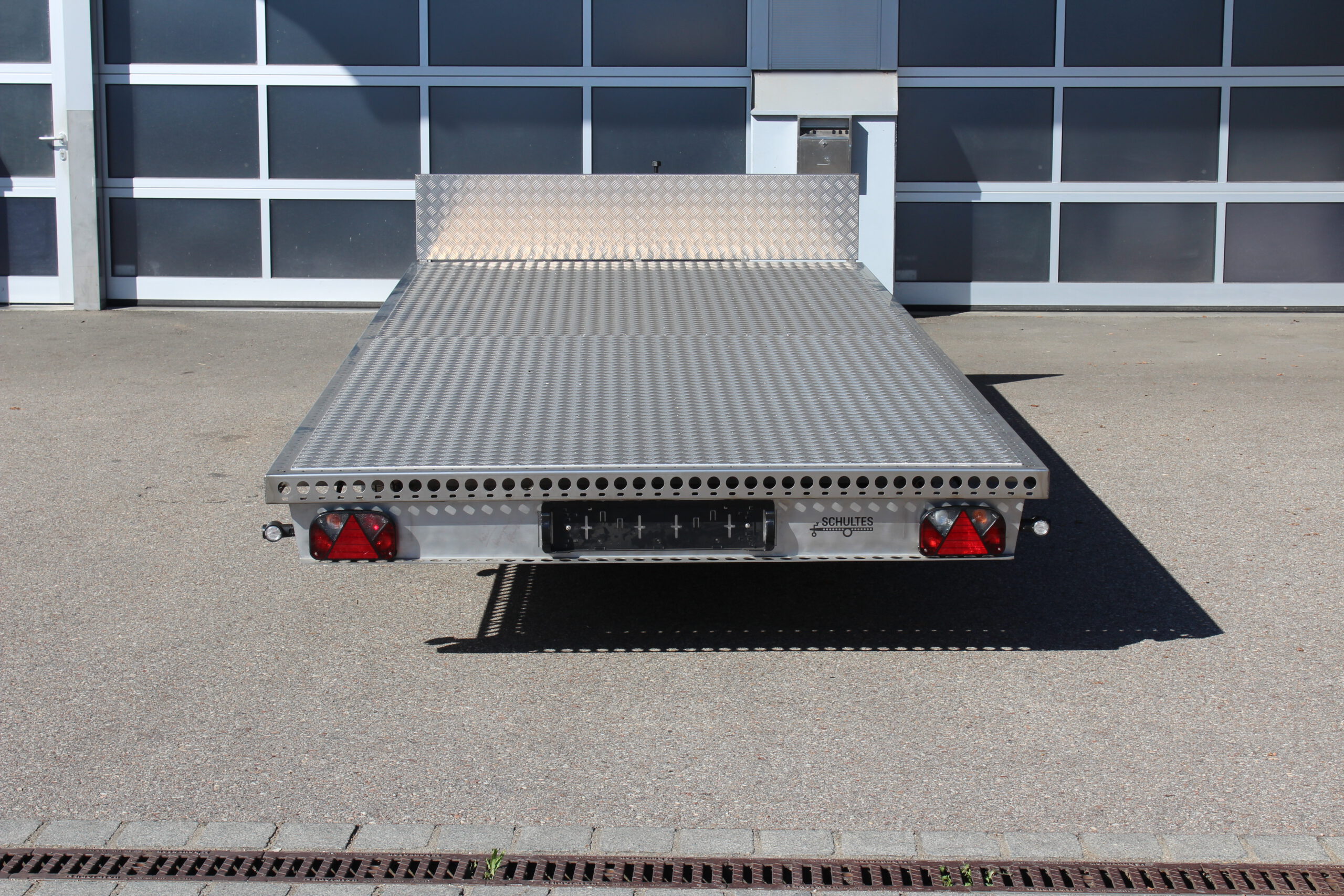 Edelstahl Anhänger 5,10m x 2,10m mit Aluminium Bodenplatte und Stirnwand. Silber, 2-Achser vor einer Halle auf einem Hof