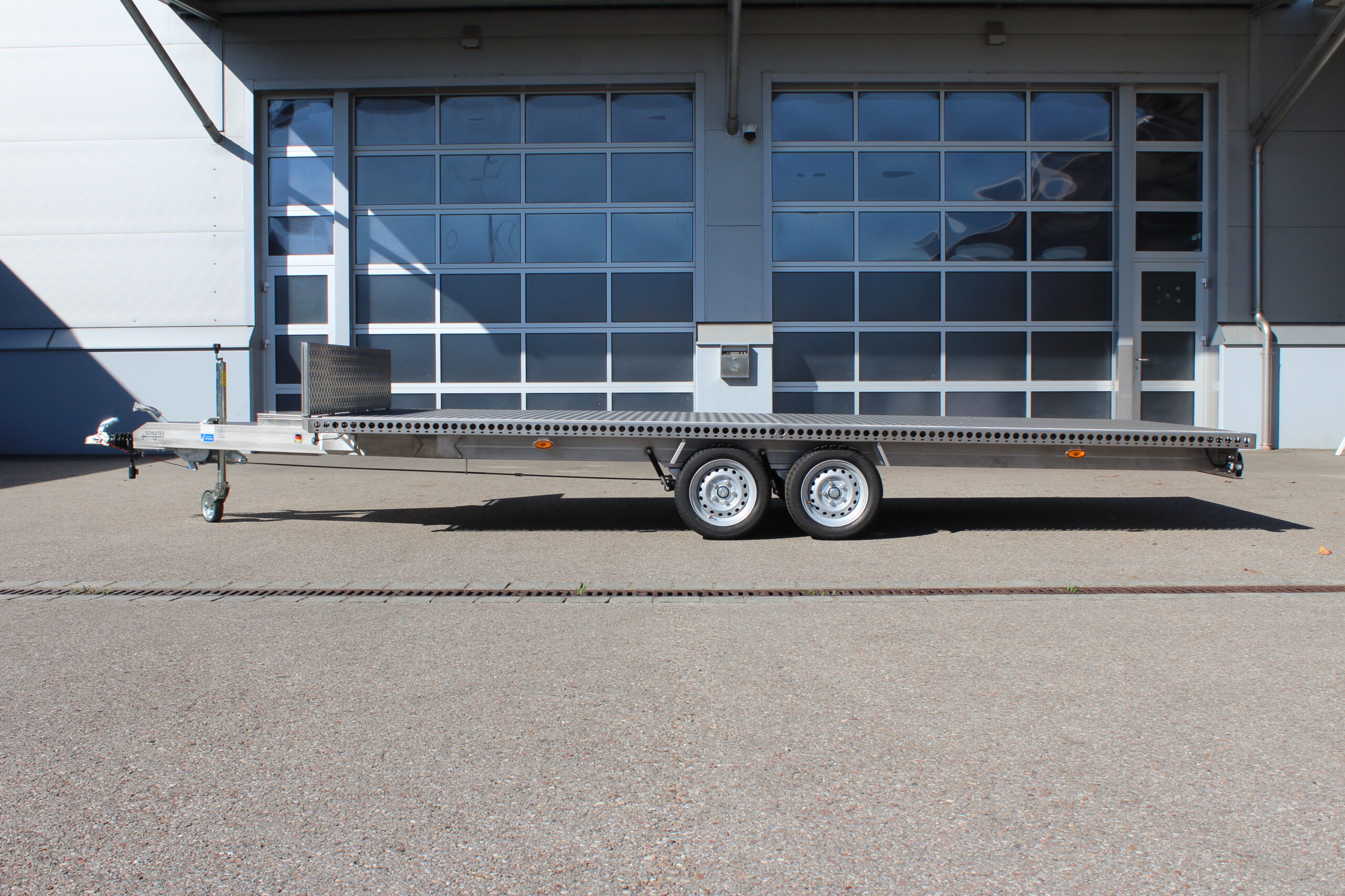 Edelstahl Anhänger 5,10m x 2,10m mit Aluminium Bodenplatte und Stirnwand. Silber, 2-Achser vor einer Halle auf einem Hof