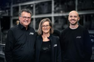 Portrait von drei Personen vor einem verschwommenen Regal