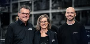 Portrait von drei Personen vor einem verschwommenen Regal