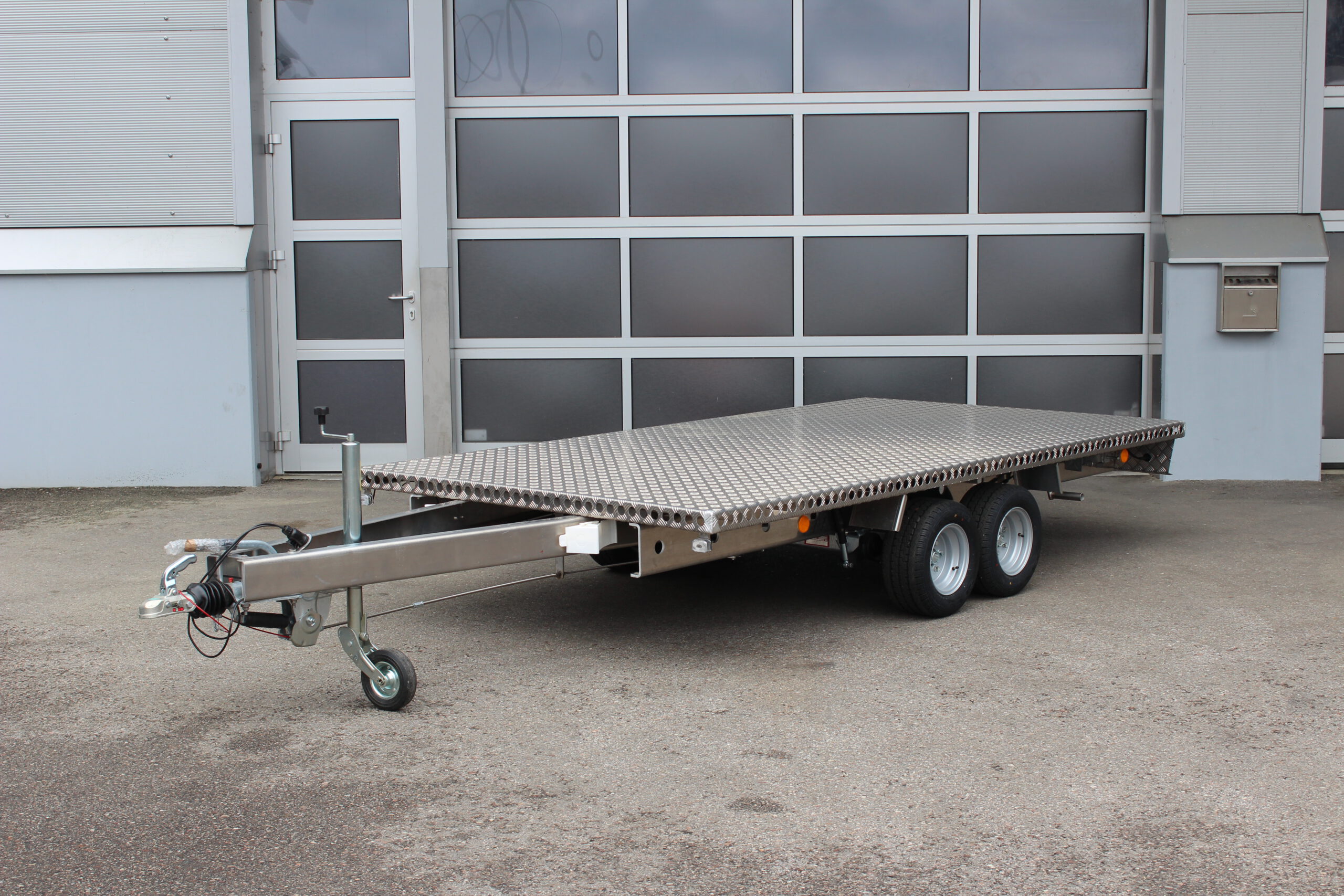 Aluminium Plattformanhänger Tandem - Ansicht von vorne - vor Hallentor
