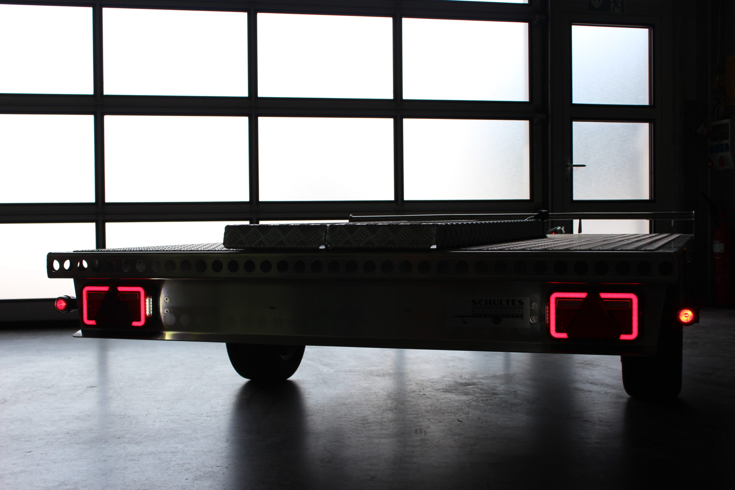 LED-Rückleuchten am Anhänger - Detailaufnahme von hinten vor einem Hallentor