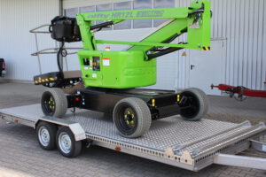 Nifty Steiger auf Edelstahl Tiefladeranhänger auf dem Hof vor einer Halle