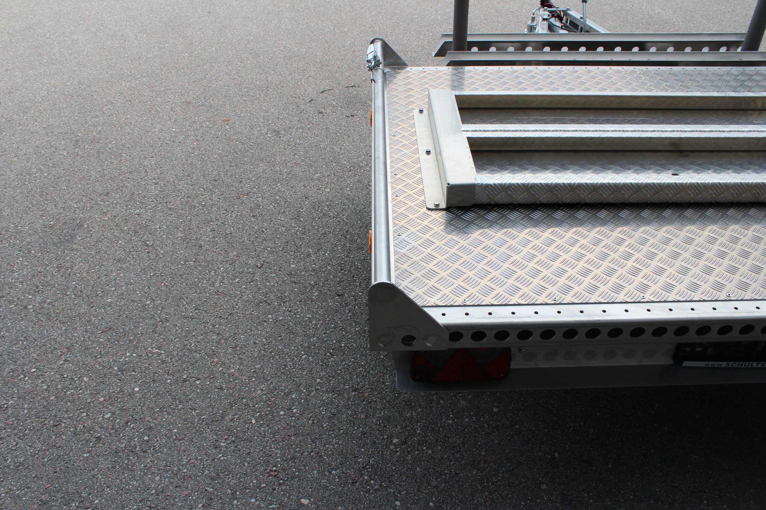 Kleiner Aluminium Plattformanhänger mit zwei Auffahrrampen und Fahrradträger - Detailaufnahme von hinten