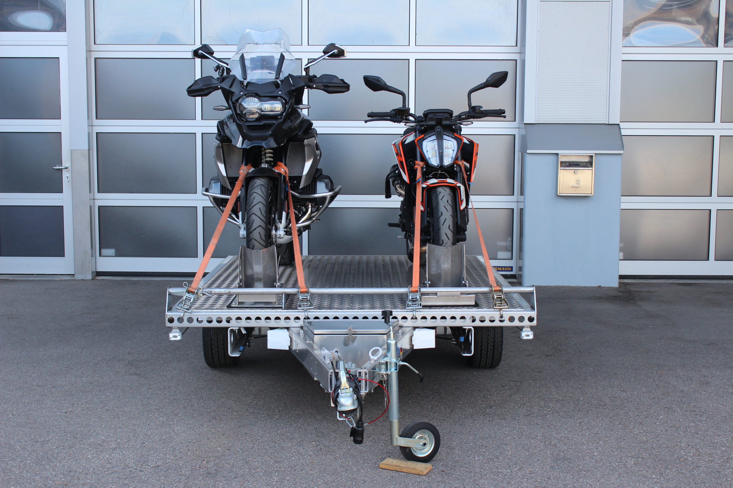 Aluminium Anhänger beladen mit BMW GS und KTM Duke vor einem Garagentor - Ansicht von vorne