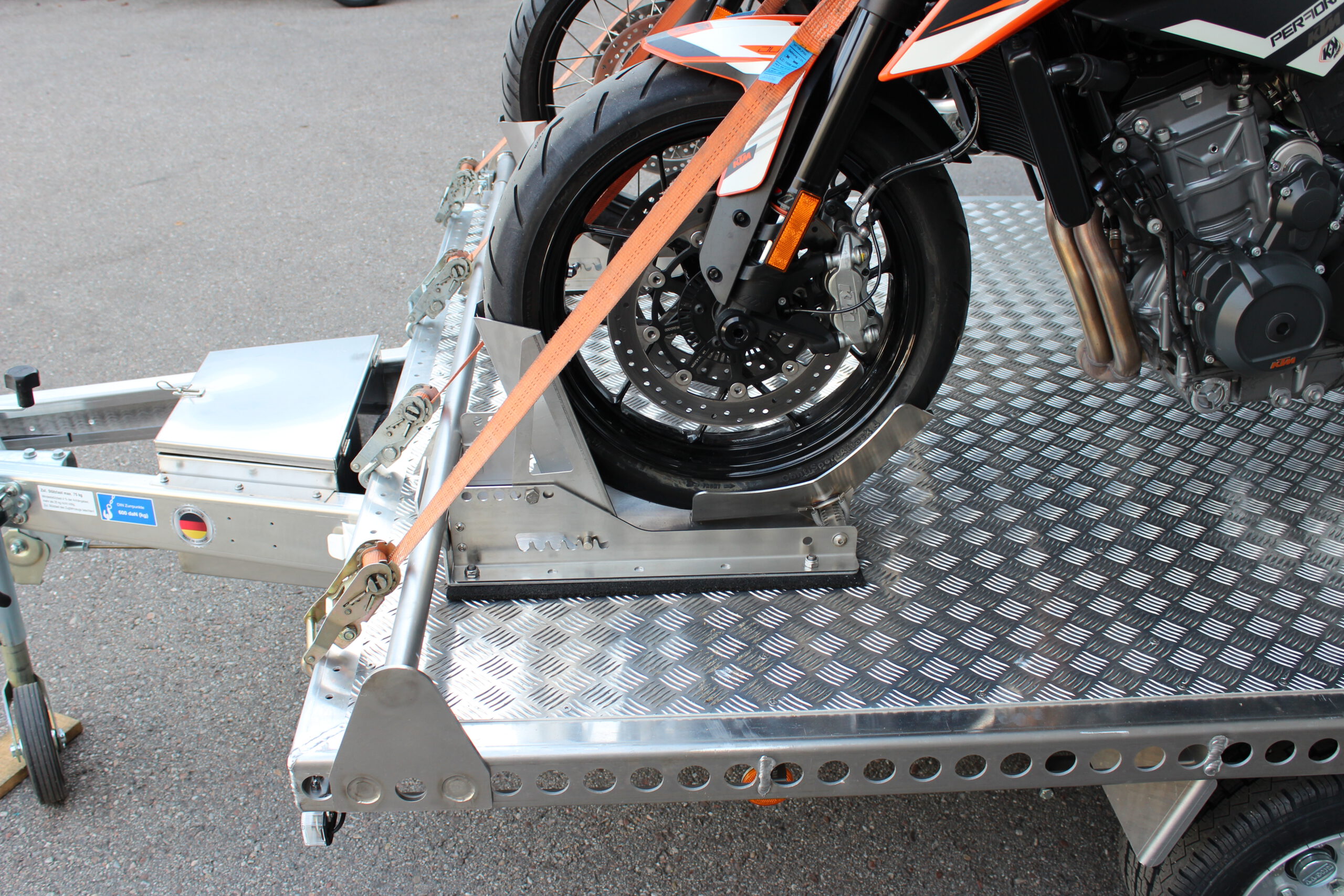 Aluminium Anhänger beladen mit BMW GS und KTM Duke Nahaufnahme vom Vorderrad in der Radwippe