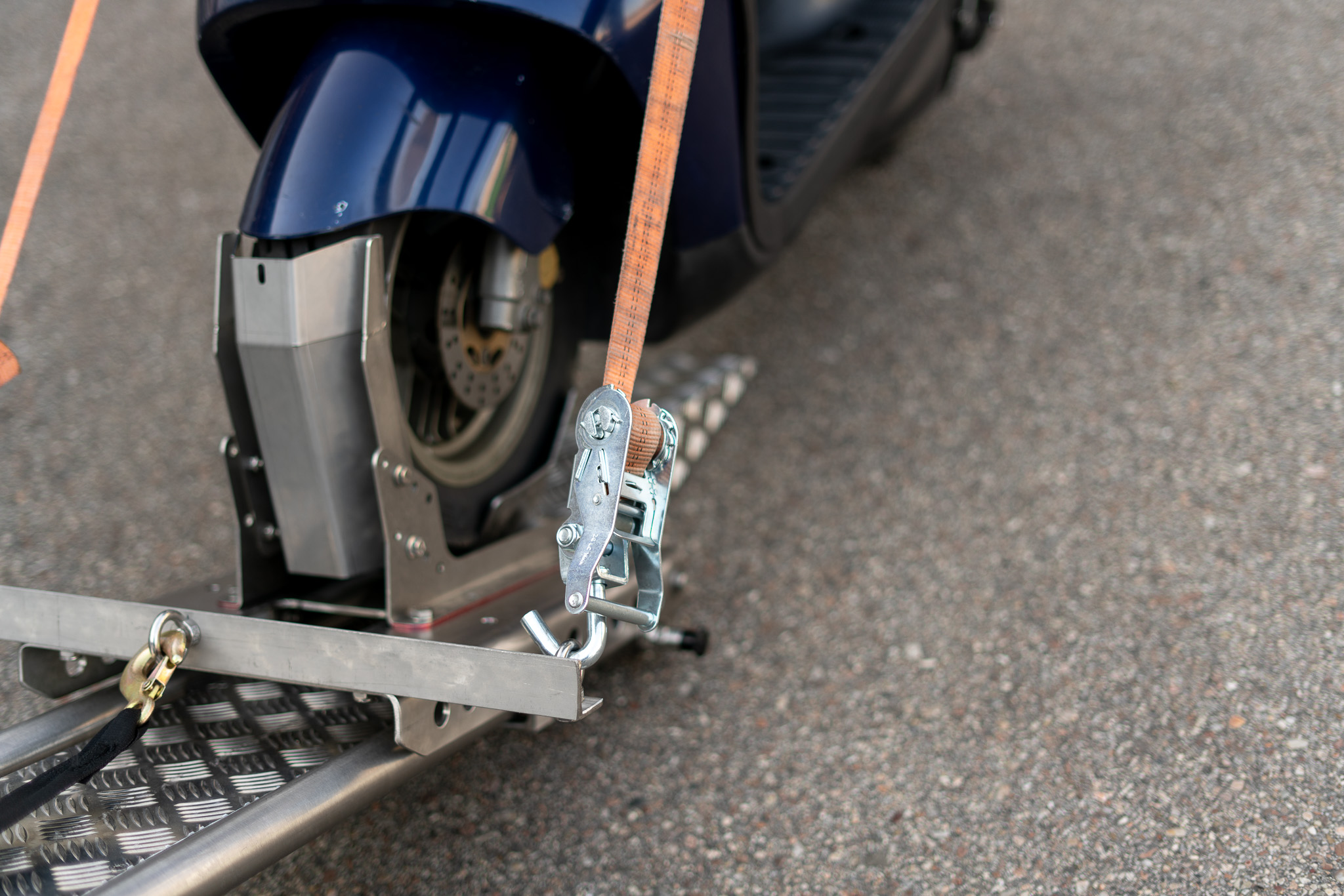 Roller in einer Rollerwippe mit zwei Zurrgurten gesichert - Motorrad Auffahrsystem - Detailaufnahme