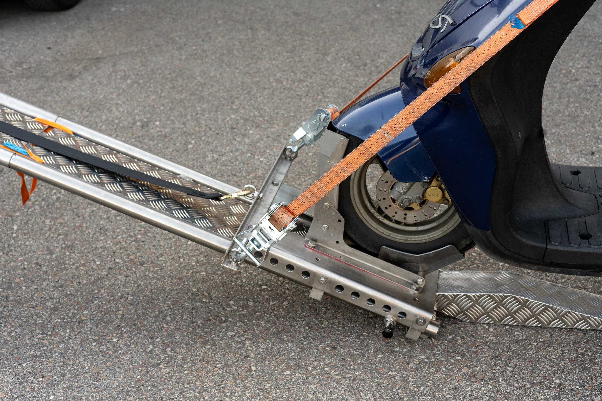 Roller in einer Rollerwippe mit zwei Zurrgurten gesichert - Motorrad Auffahrsystem - Detailaufnahme