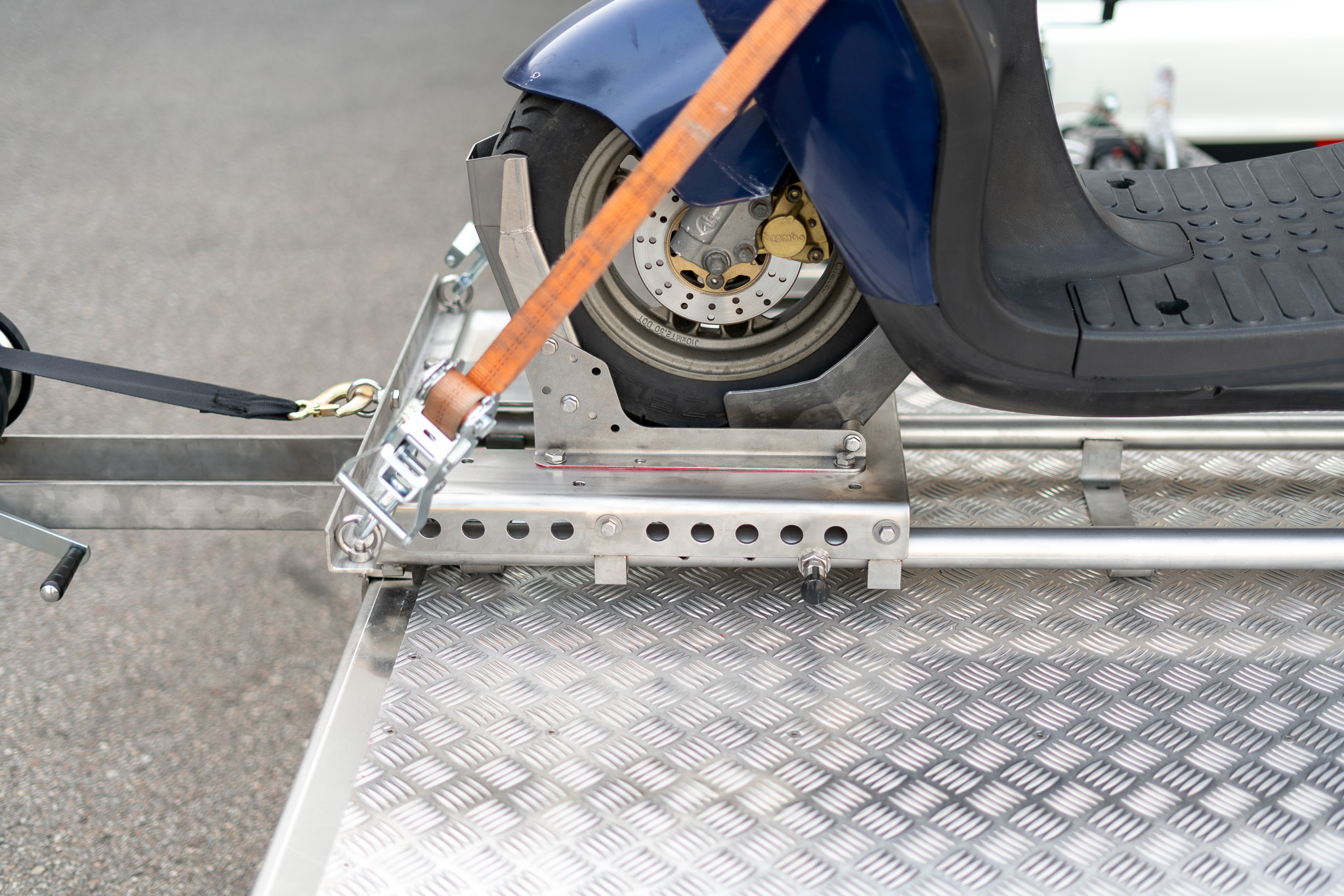 Roller in einer Rollerwippe mit zwei Zurrgurten gesichert - Motorrad Auffahrsystem - Detailaufnahme
