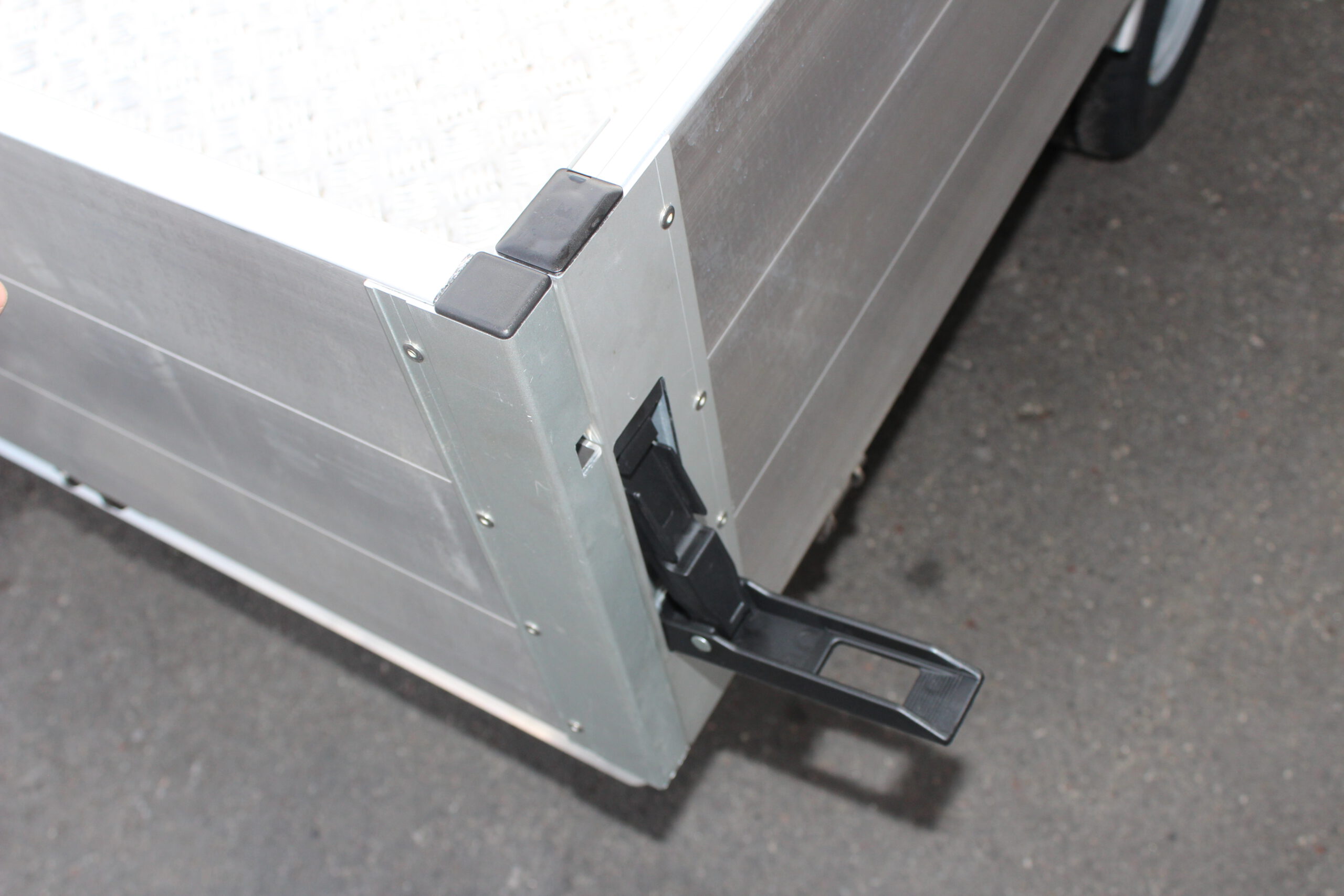 Aluminium Plattformanhänger mit Aluminium Bordwänden vor einem Hallentor