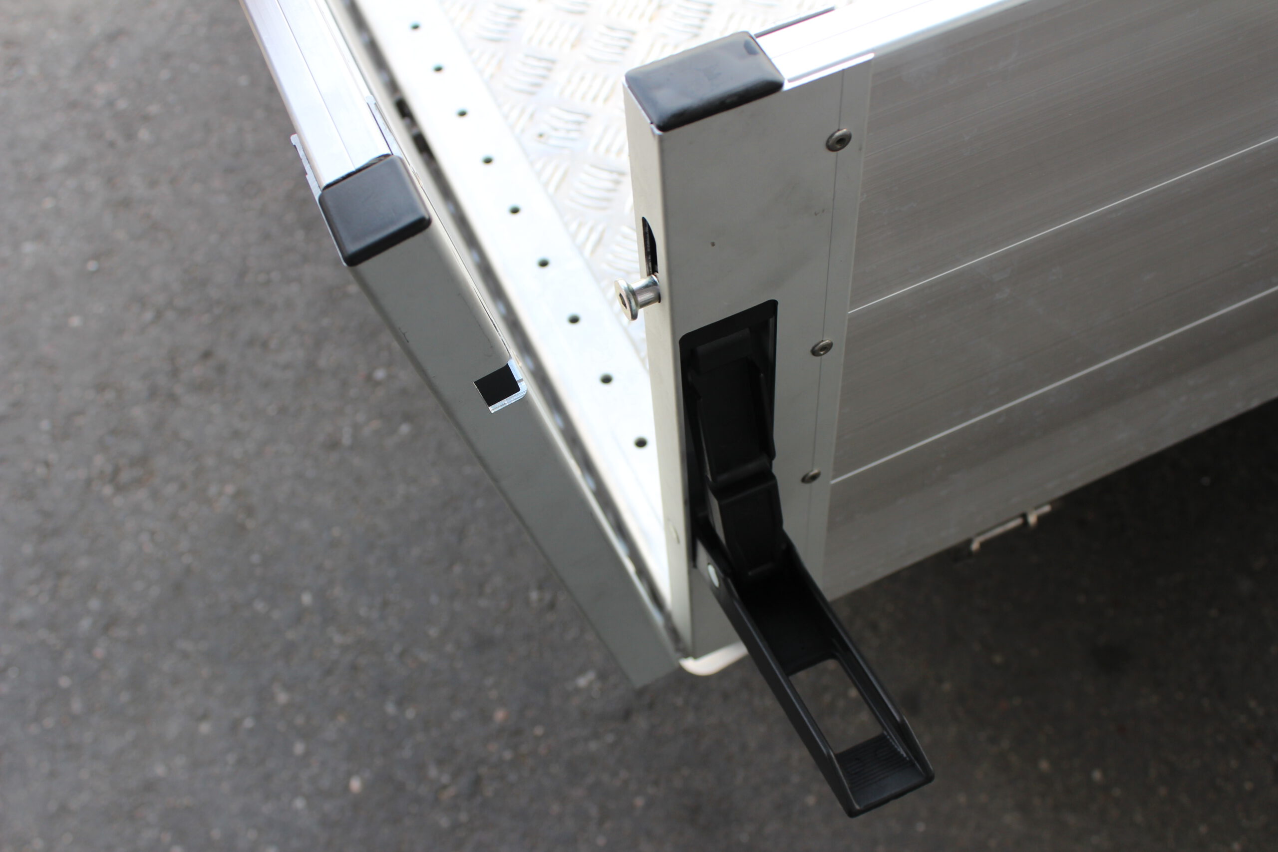 Aluminium Plattformanhänger mit Aluminium Bordwänden vor einem Hallentor