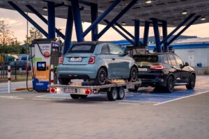 Tandem Auto-Anhänger mit einem FIAT 500 beladen an einer Elektro-Ladestation
