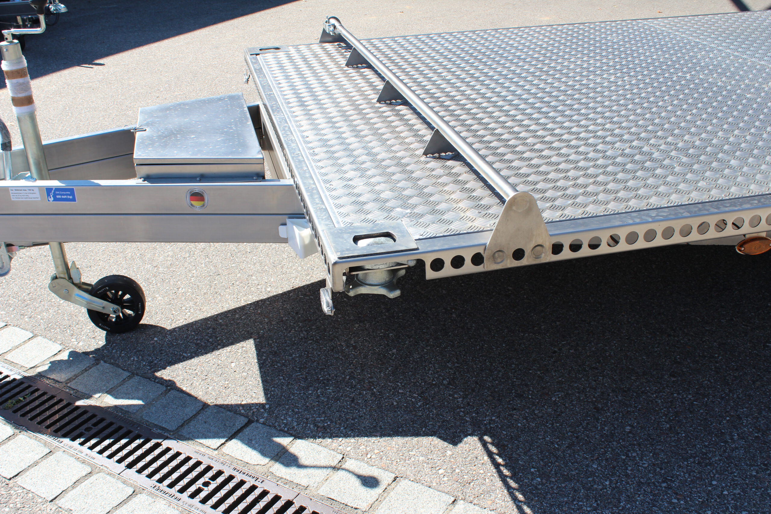 UA600 Container2 Edelstahl Plattform Anhänger mit Twistlock aufnahmen an den 4 Ecken zum Befestigen eines Übersee-Containers. Containertransporter und Plattformanhänger vor einer Halle