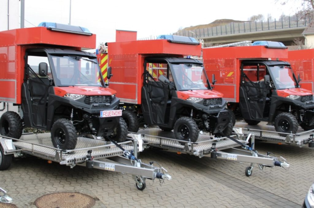 Aluminium Absenkanhänger mit umgebauten Rettungs-UTV in rot auf einem Hof