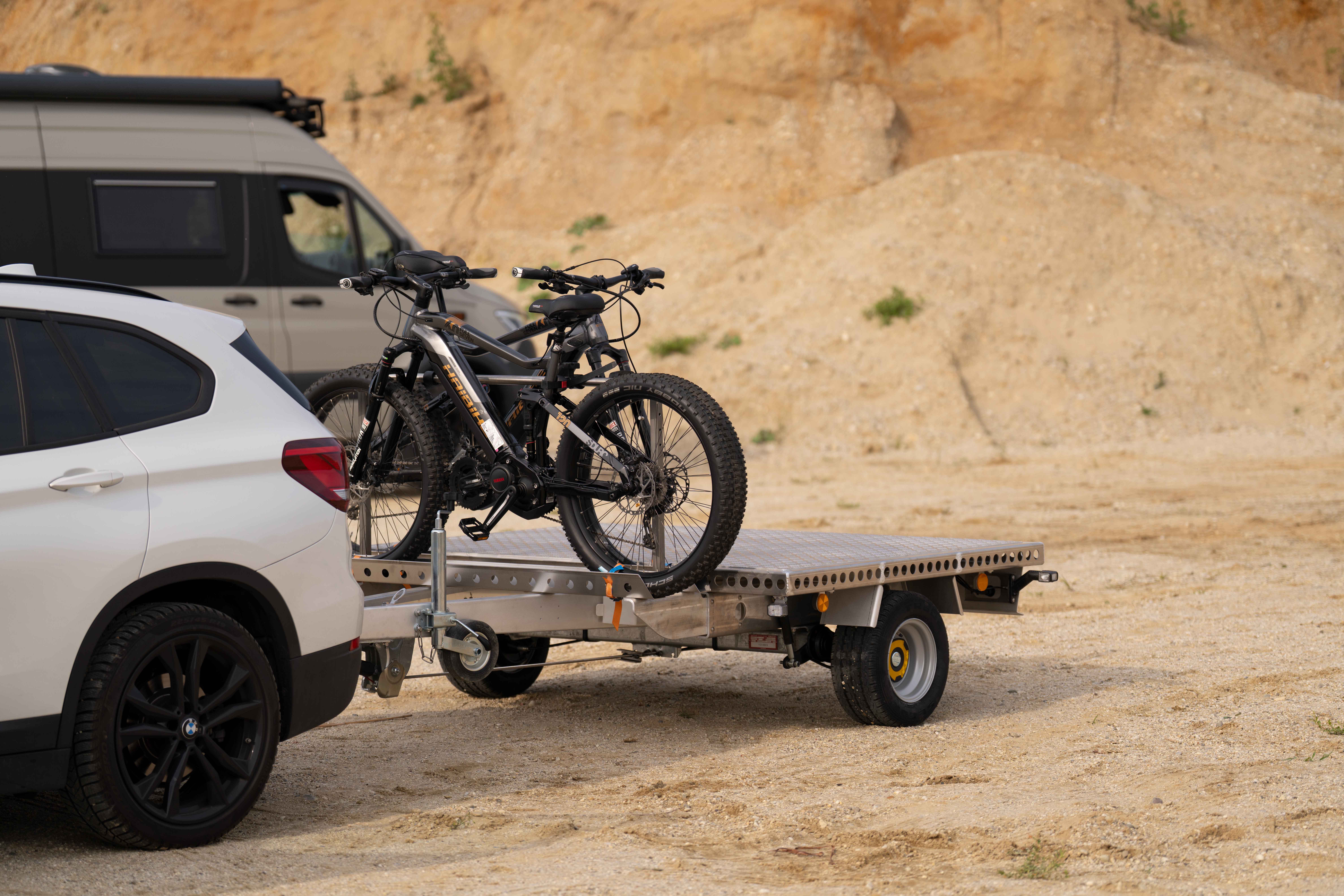 Aluminium Plattformanhänger mit zwei E-Bikes auf einer Sandfläche