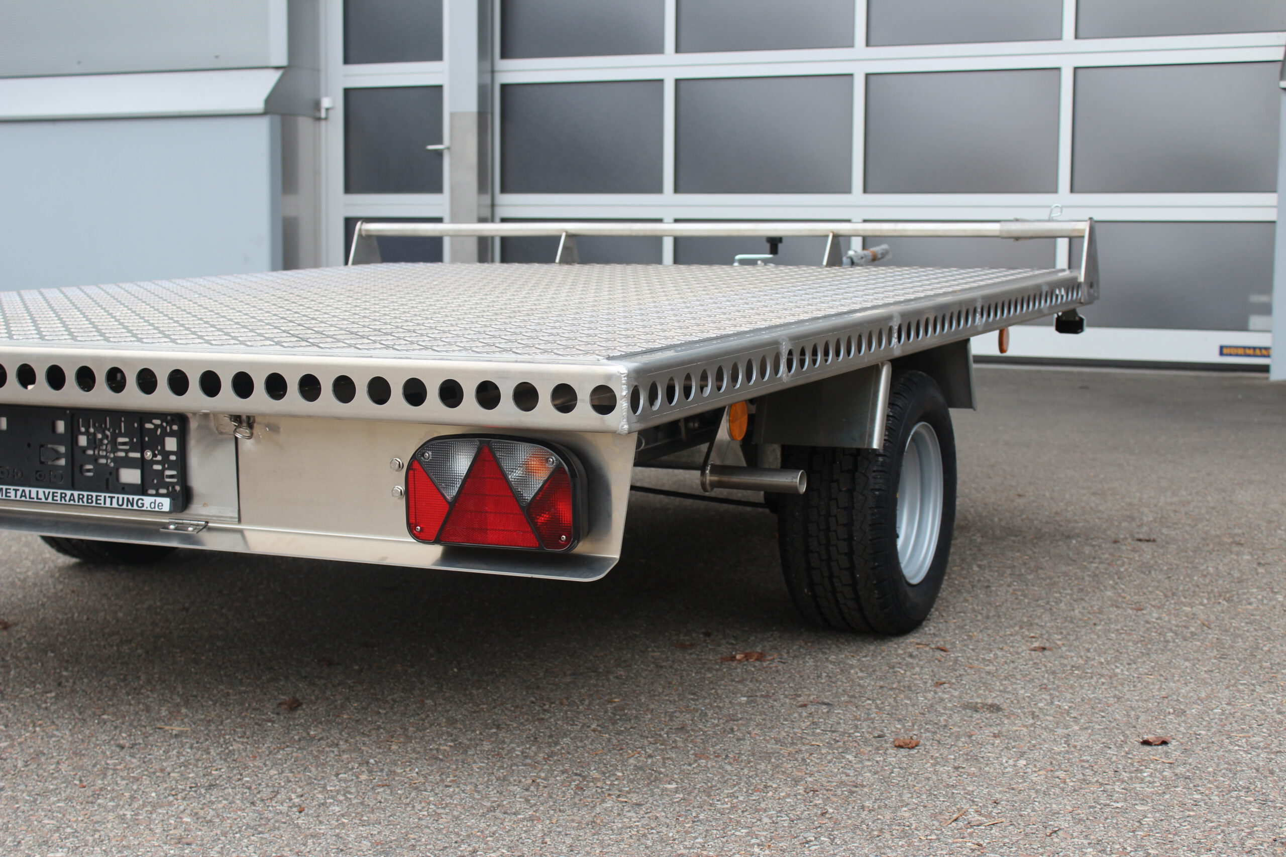 Aluminium Plattformanhänger 2,5m x 1,9m vor einem Hallentor