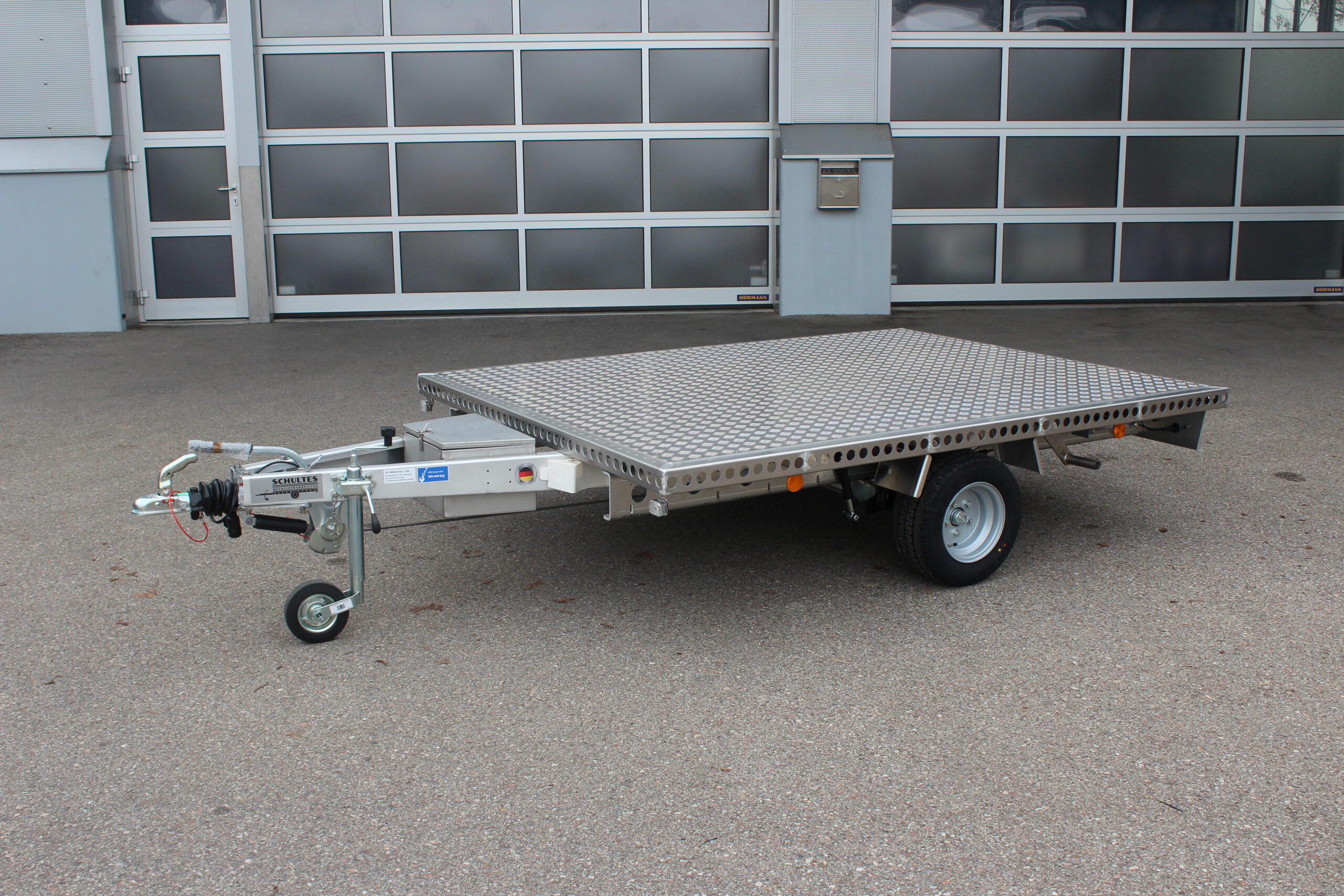Aluminium Plattformanhänger 2,5m x 1,9m vor einem Hallentor
