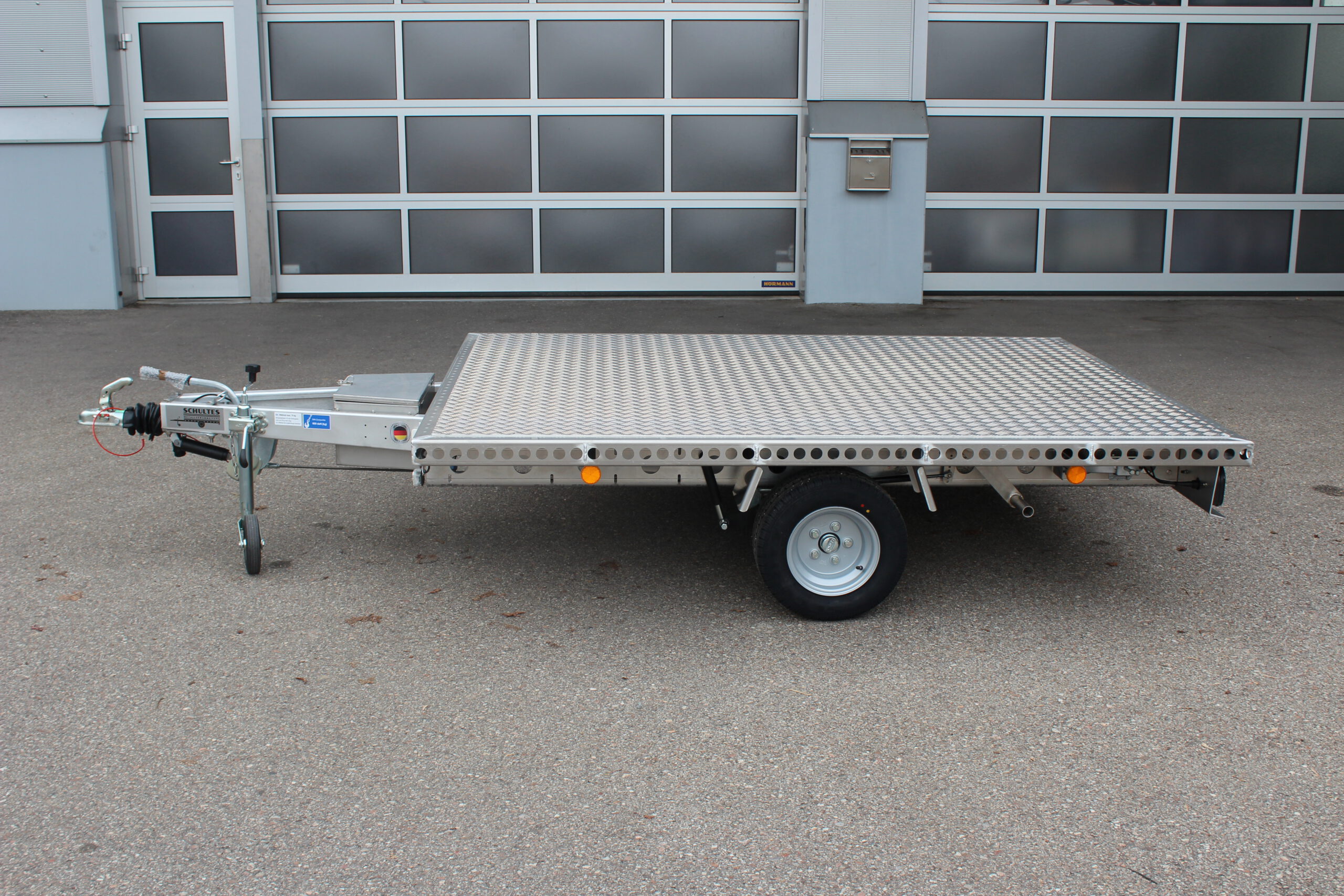 Aluminium Plattformanhänger 2,5m x 1,9m vor einem Hallentor