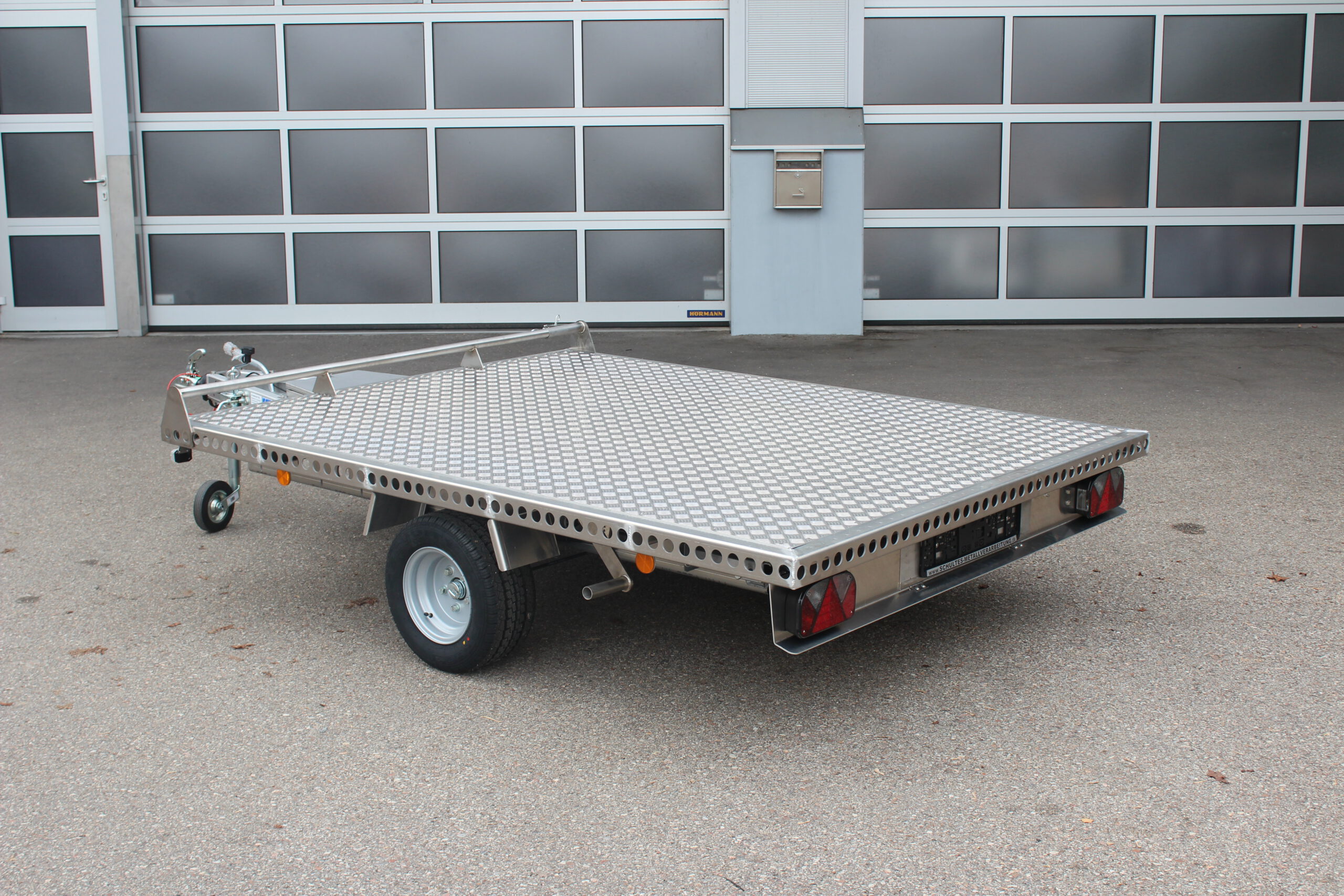 Aluminium Plattformanhänger 2,5m x 1,9m vor einem Hallentor