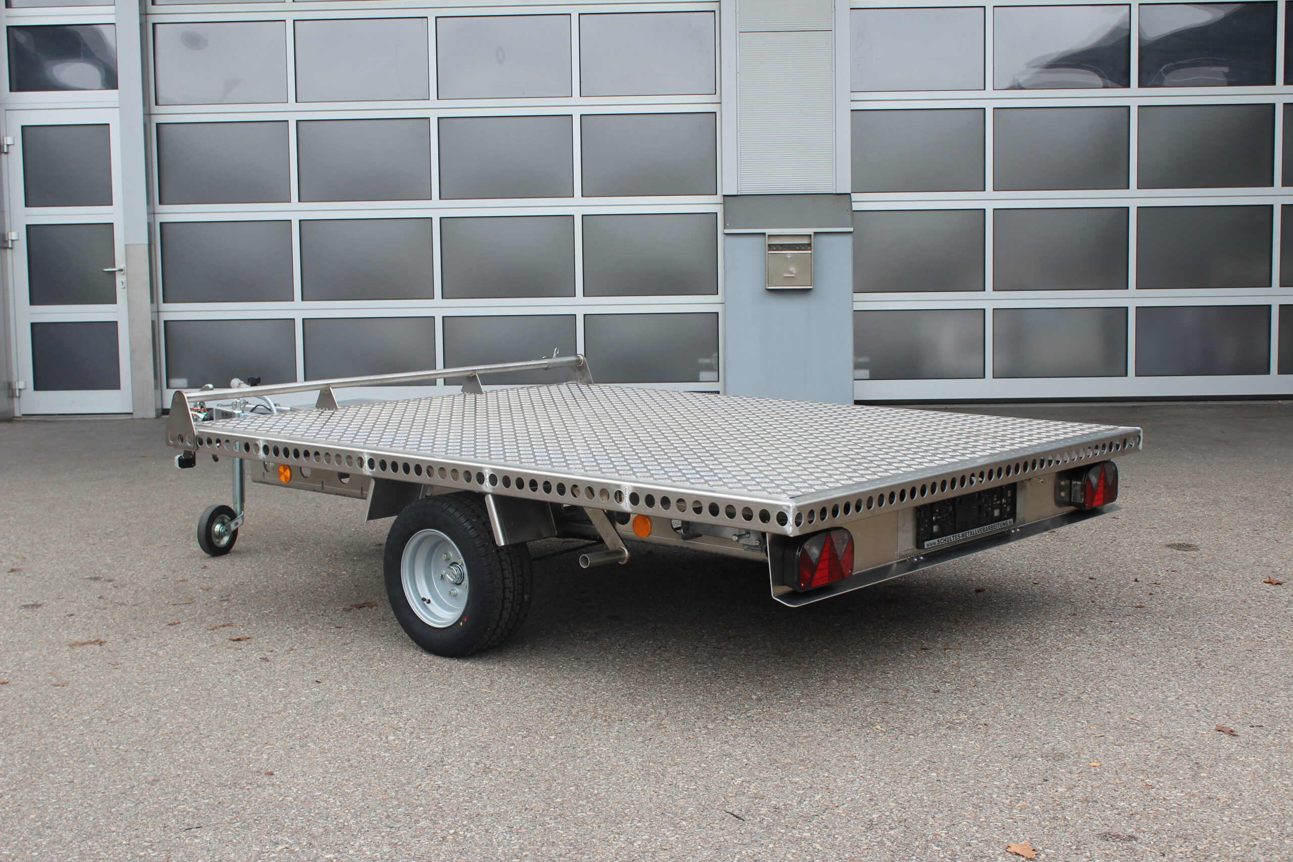 Aluminium Plattformanhänger 2,5m x 1,9m vor einem Hallentor