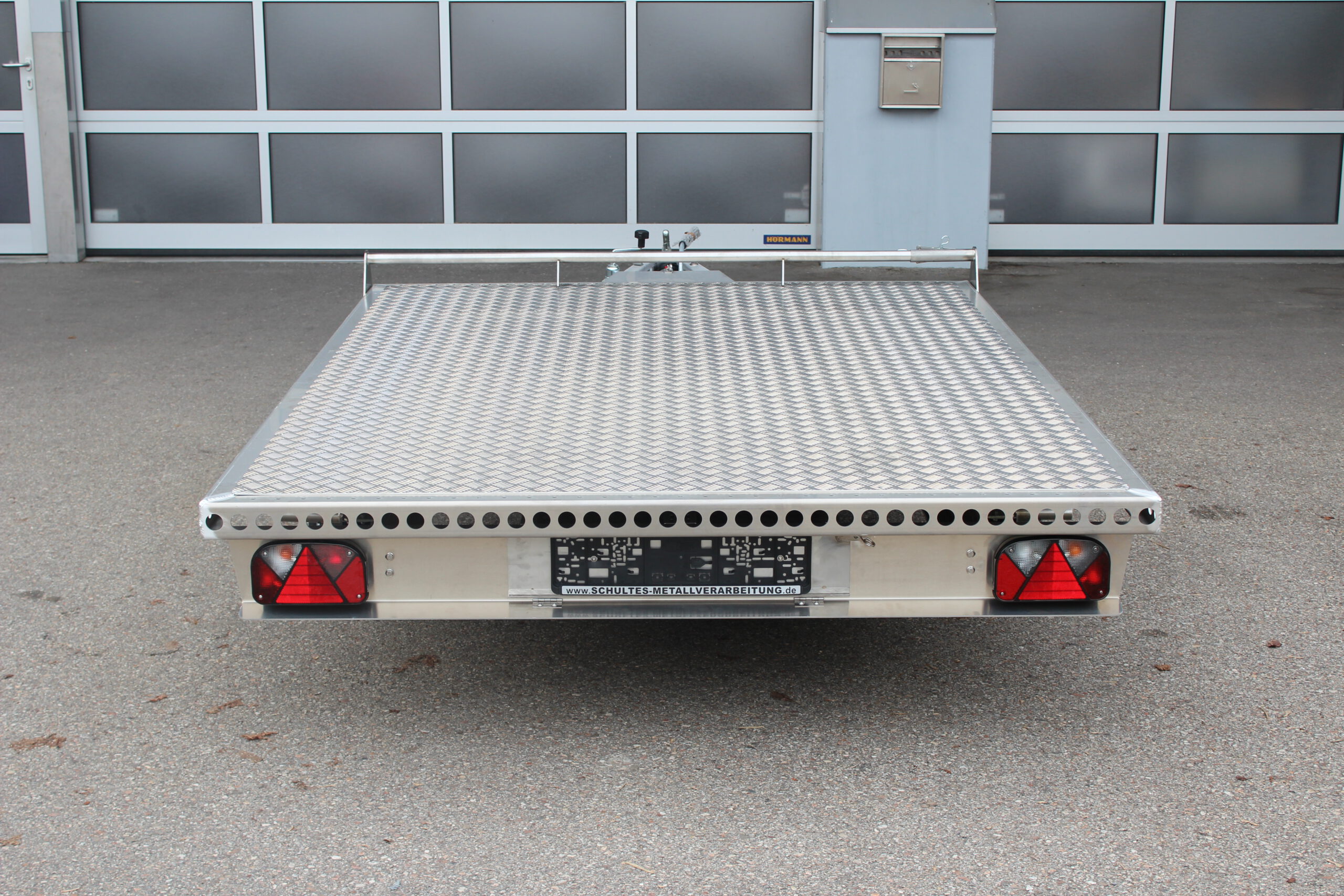 Aluminium Plattformanhänger 2,5m x 1,9m vor einem Hallentor