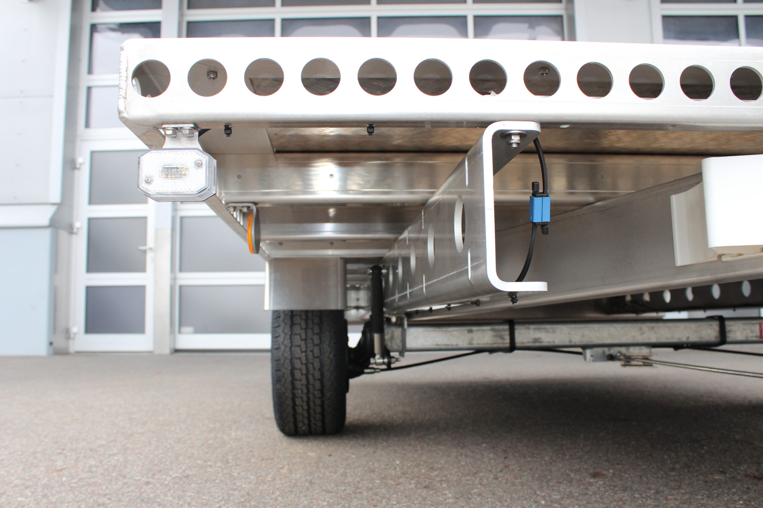 Aluminium Plattform-Anhänger 3,0m x 2,0m vor einem Hallentor