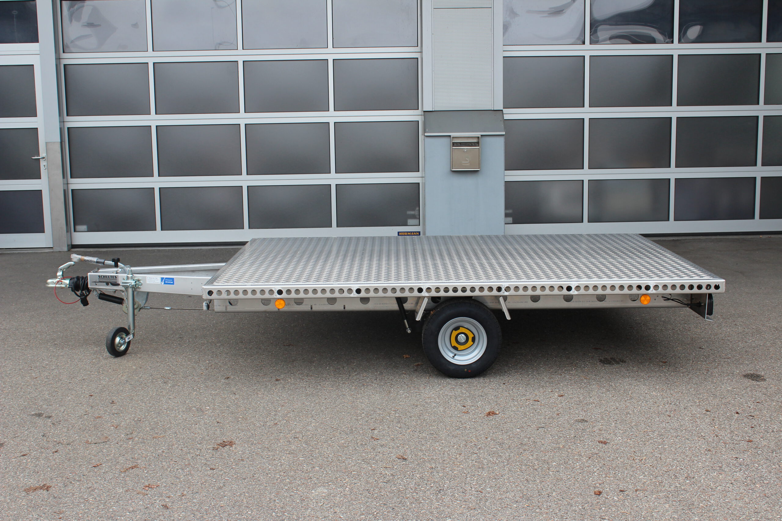 Aluminium Plattform-Anhänger 3,0m x 2,0m vor einem Hallentor