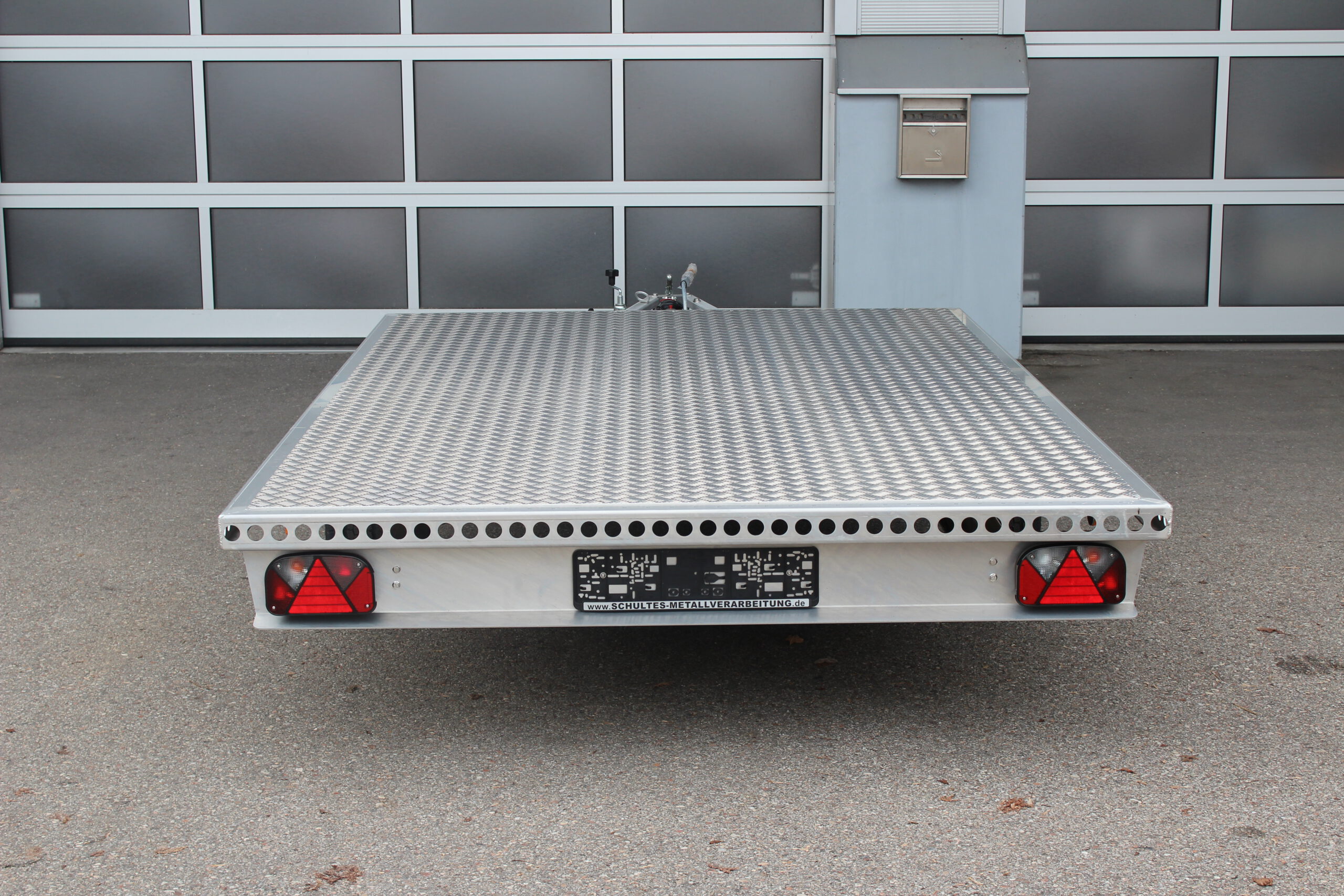 Aluminium Plattform-Anhänger 3,0m x 2,0m vor einem Hallentor
