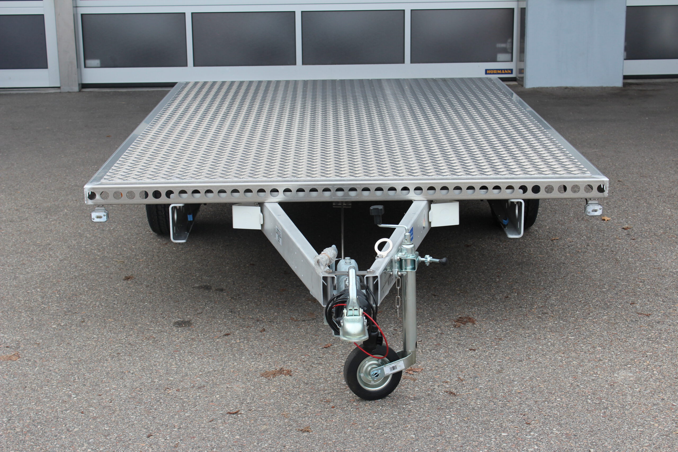 Aluminium Plattform-Anhänger 3,0m x 2,0m vor einem Hallentor