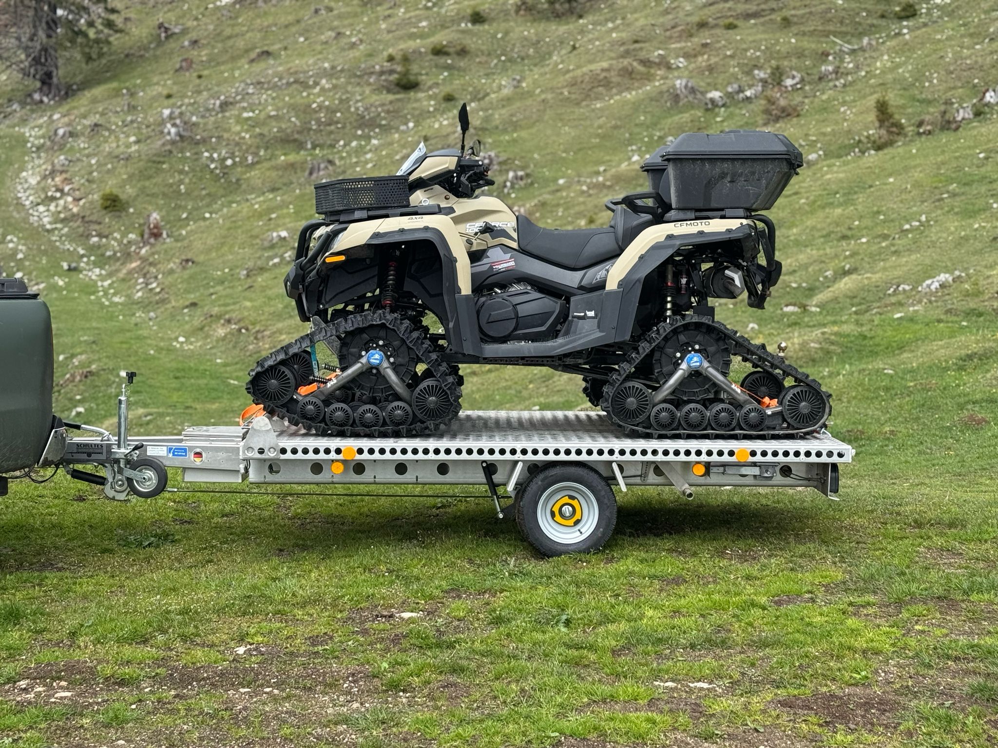 Aluminium Plattformanhänger mit einem grauen Quad beladen auf einer grünen Wiese