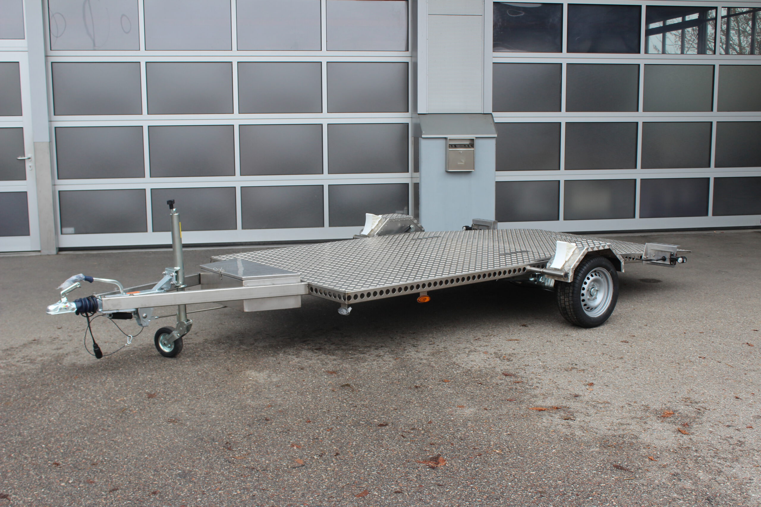 Absenkbarer Anhänger aus Edelstahl vor einem Hallentor
