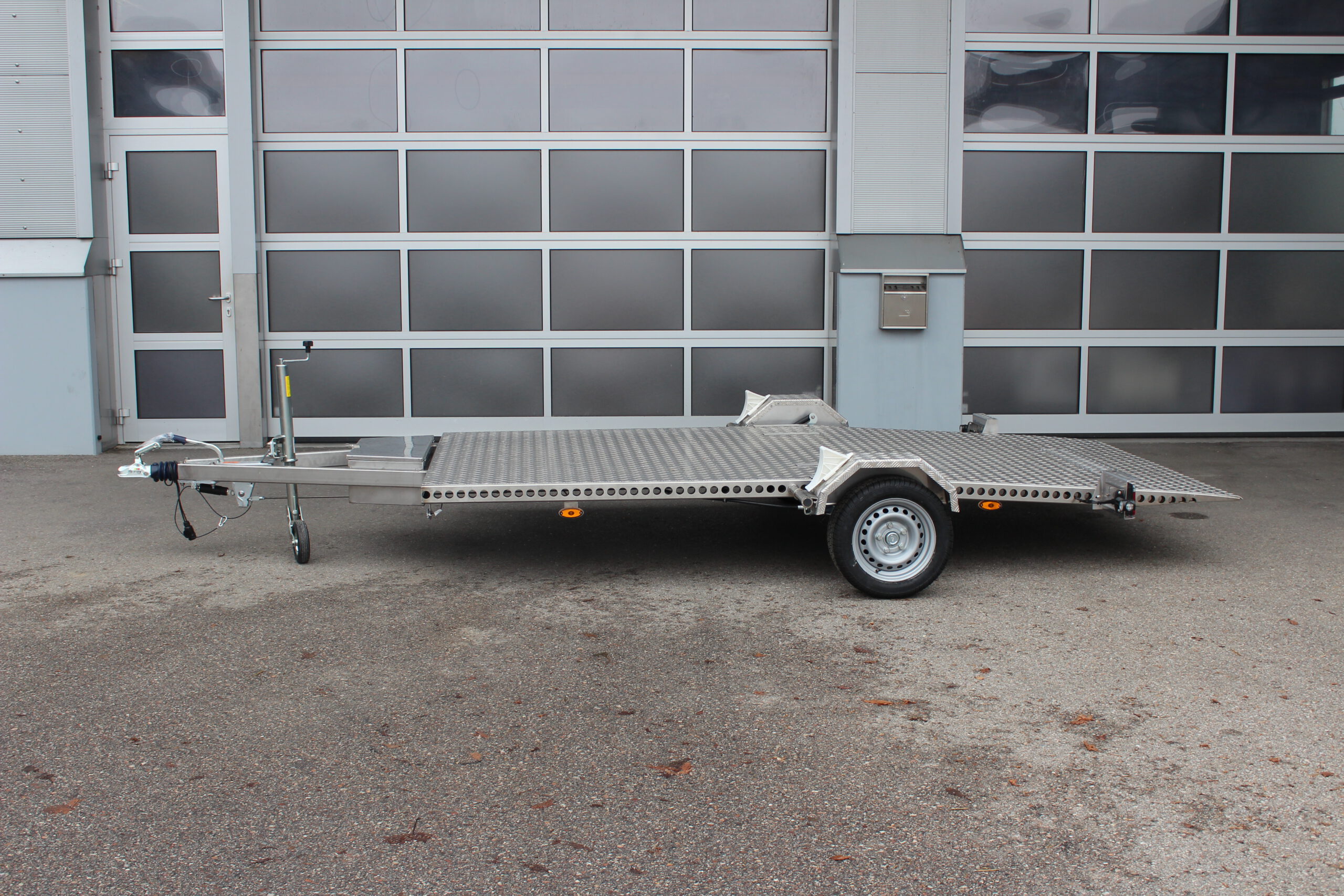 Absenkbarer Anhänger aus Edelstahl vor einem Hallentor