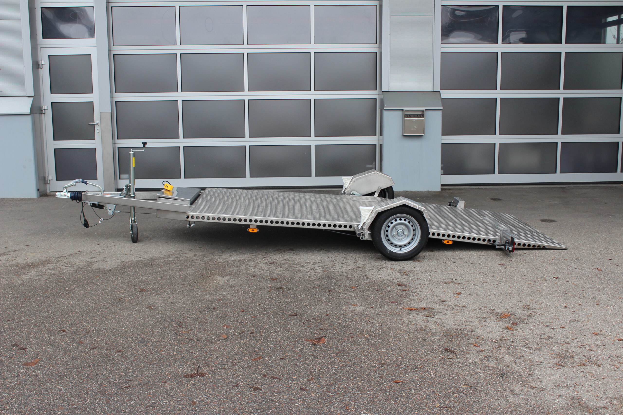 Absenkbarer Anhänger aus Edelstahl vor einem Hallentor