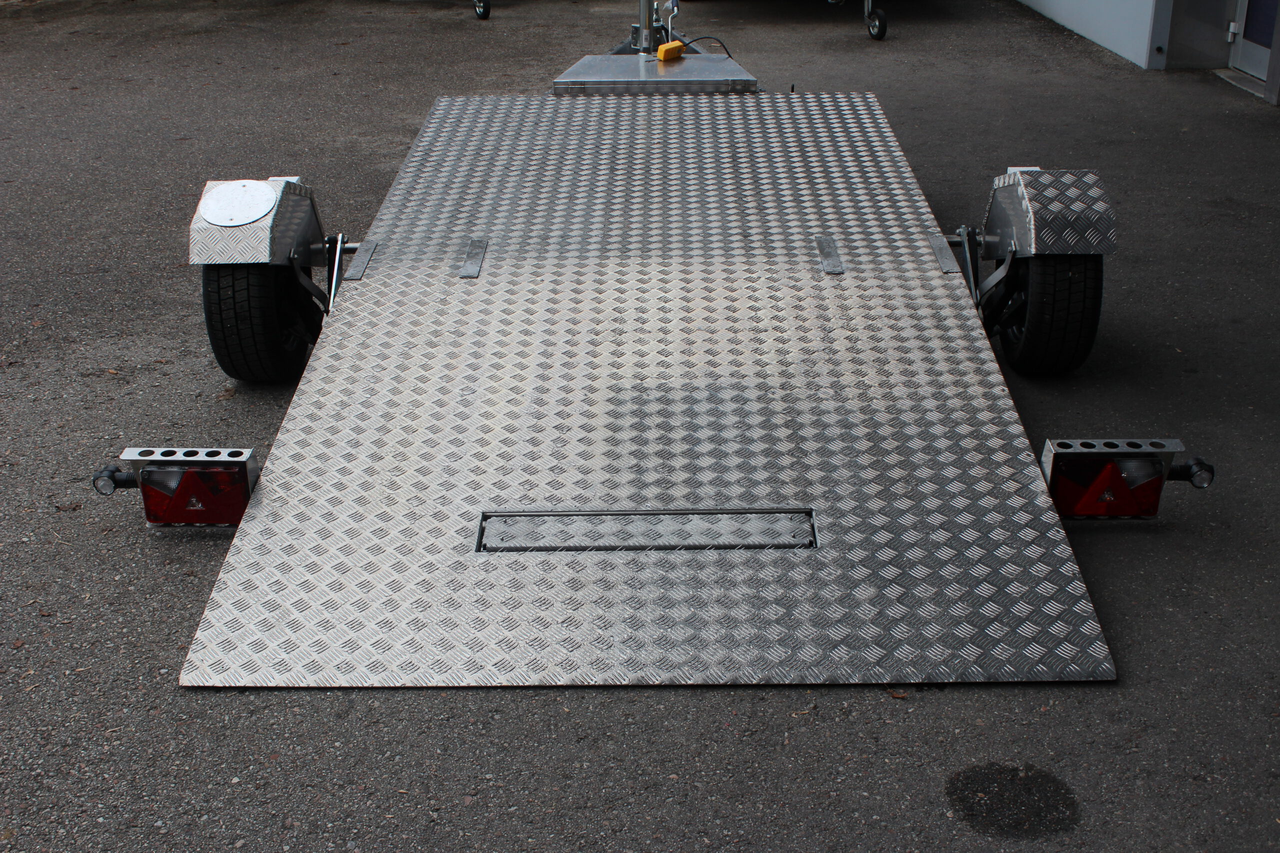 Absenkbarer Anhänger aus Edelstahl vor einem Hallentor