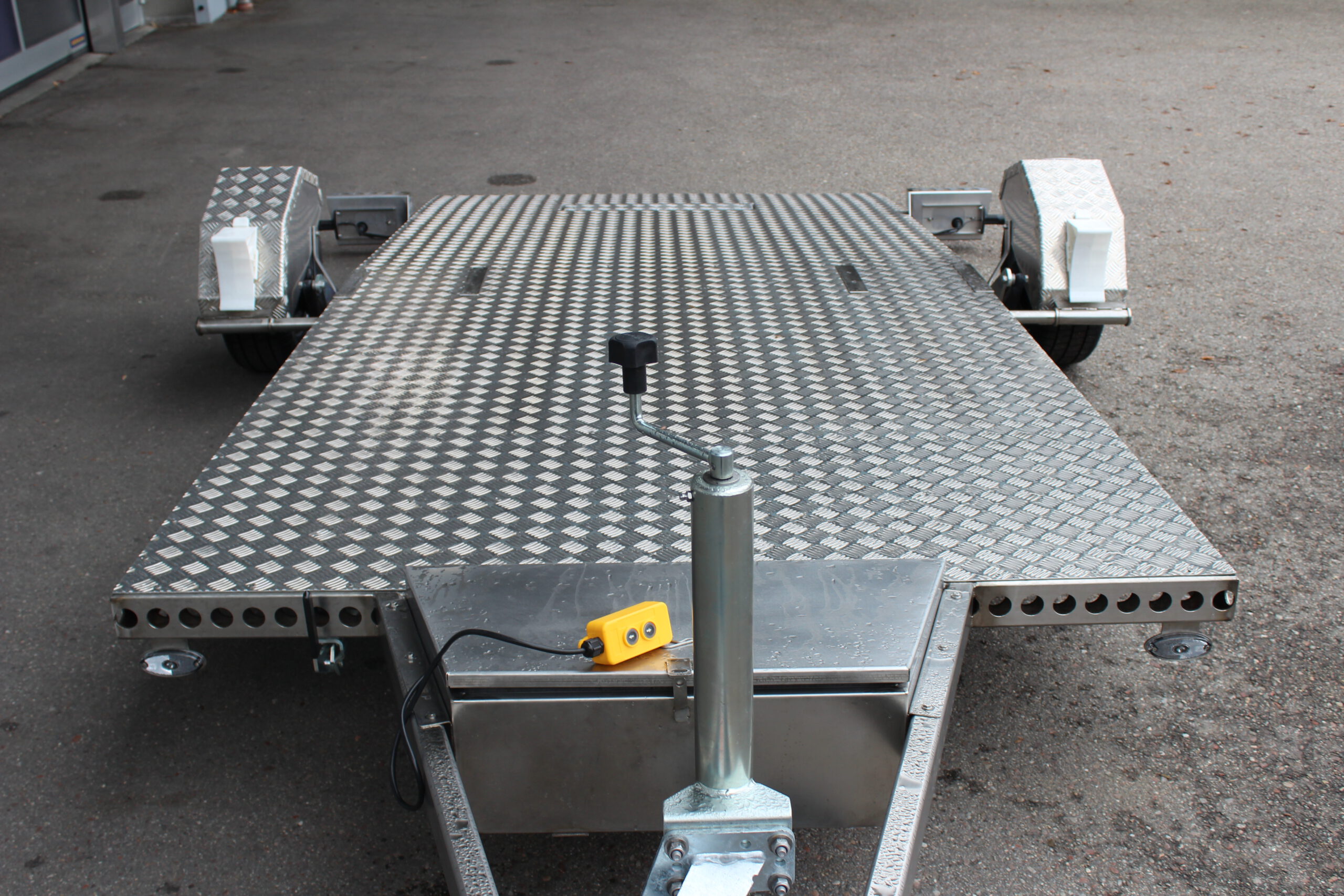 Absenkbarer Anhänger aus Edelstahl vor einem Hallentor