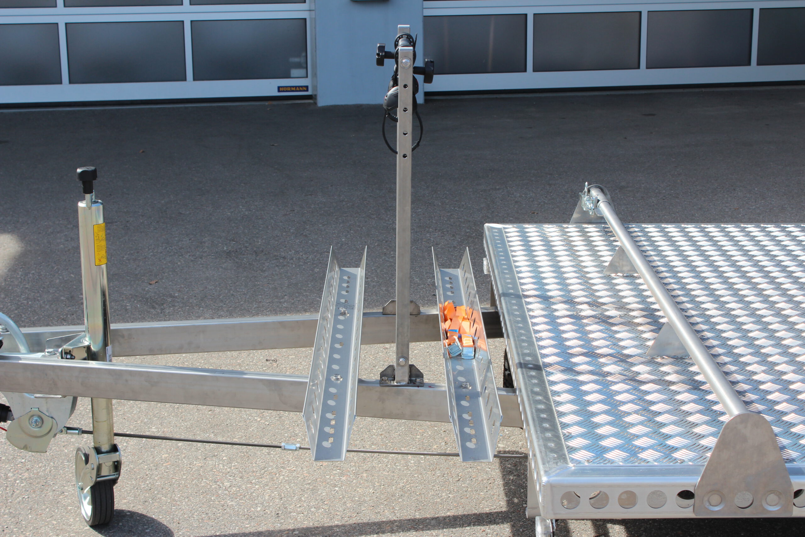 Fahrradträger für 2 Fahrräder aus Edelstahl an einem Anhänger befestigt vor einer Halle