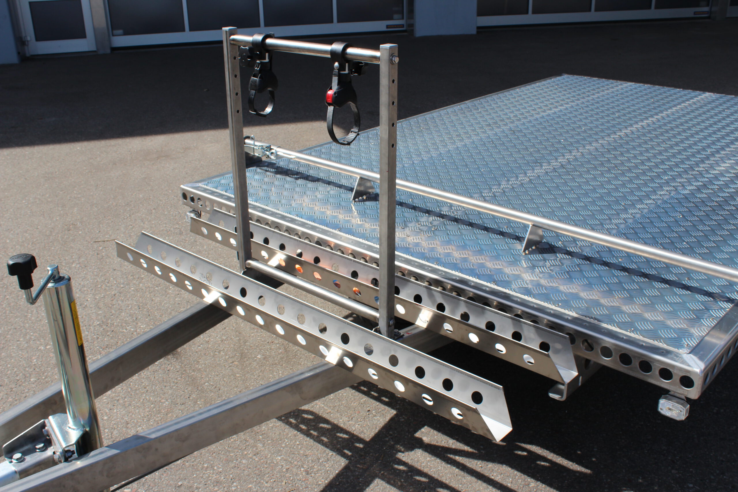 Fahrradträger für 2 Fahrräder aus Edelstahl an einem Anhänger befestigt vor einer Halle