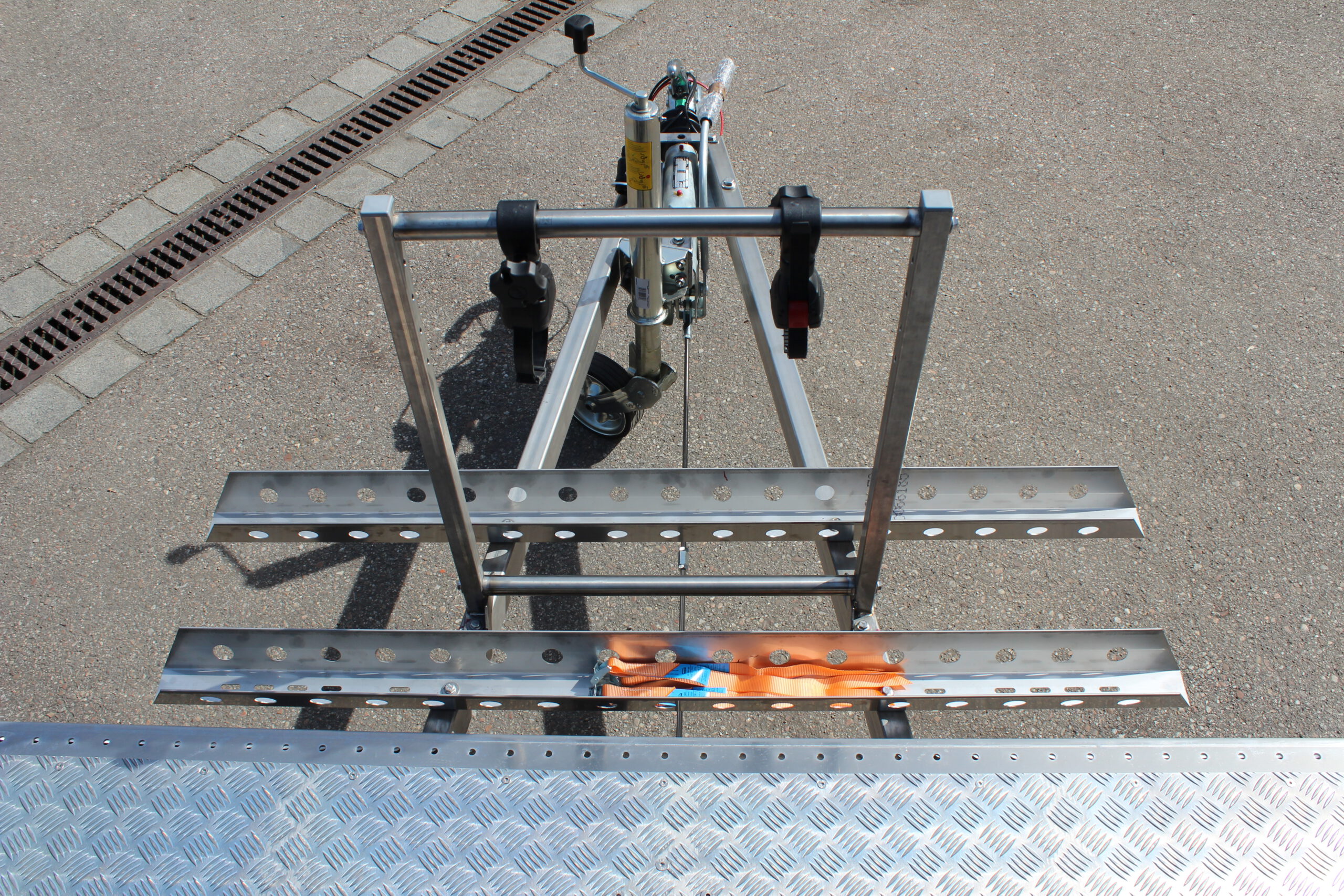 Fahrradträger für 2 Fahrräder aus Edelstahl an einem Anhänger befestigt vor einer Halle