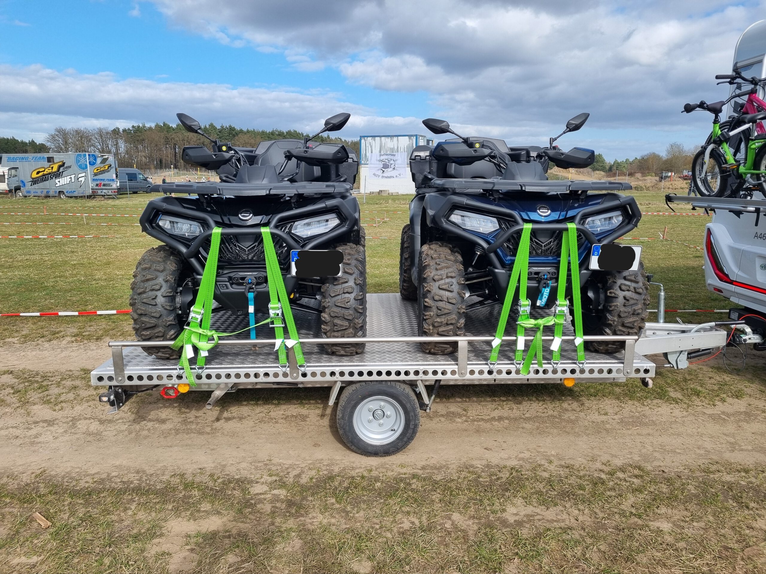 Aluminium Anhänger mit zwei Quad beladen an einem Wohnmobil auf einer Wiese