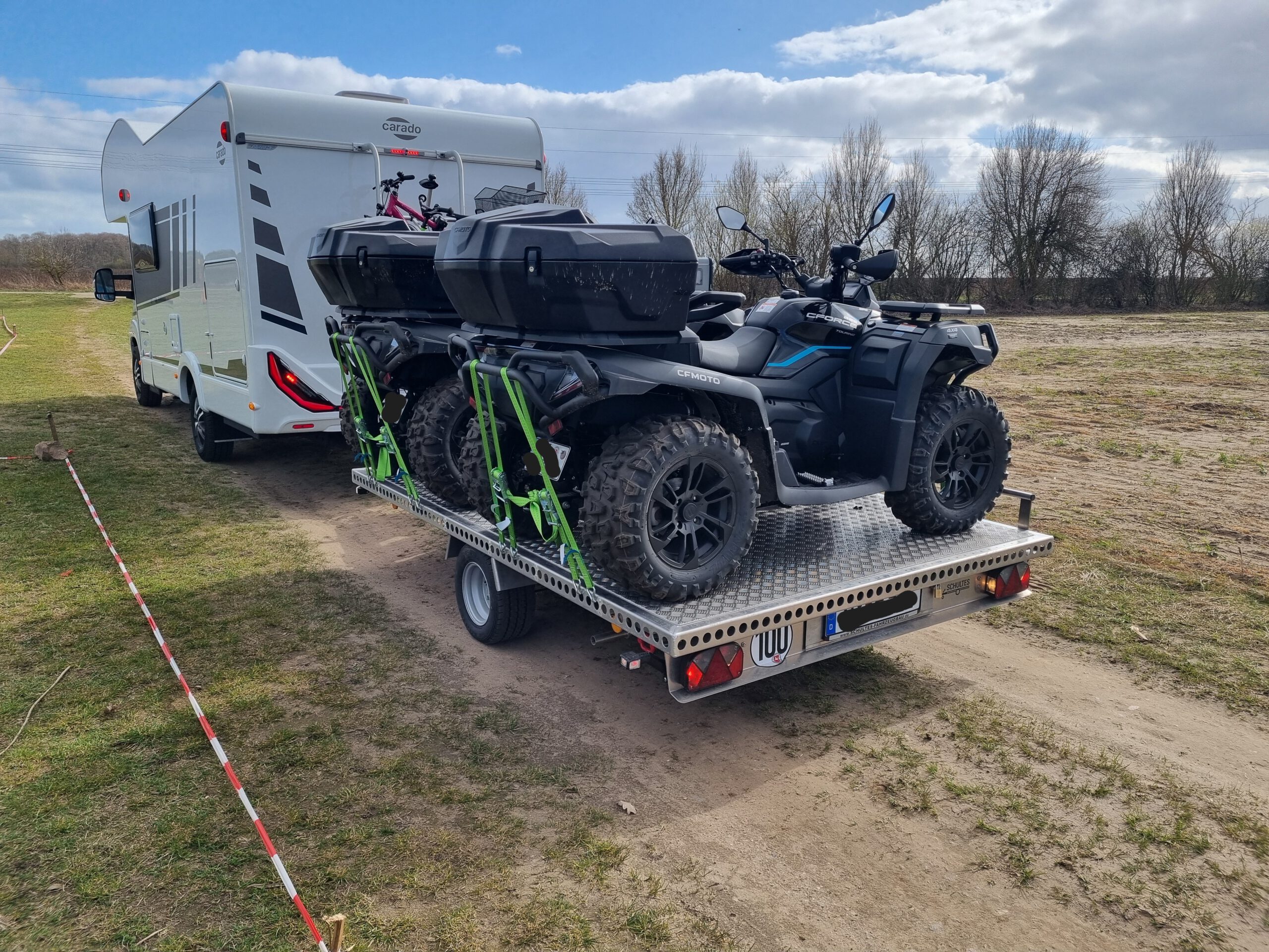 Aluminium Anhänger mit zwei Quad beladen an einem Wohnmobil auf einer Wiese