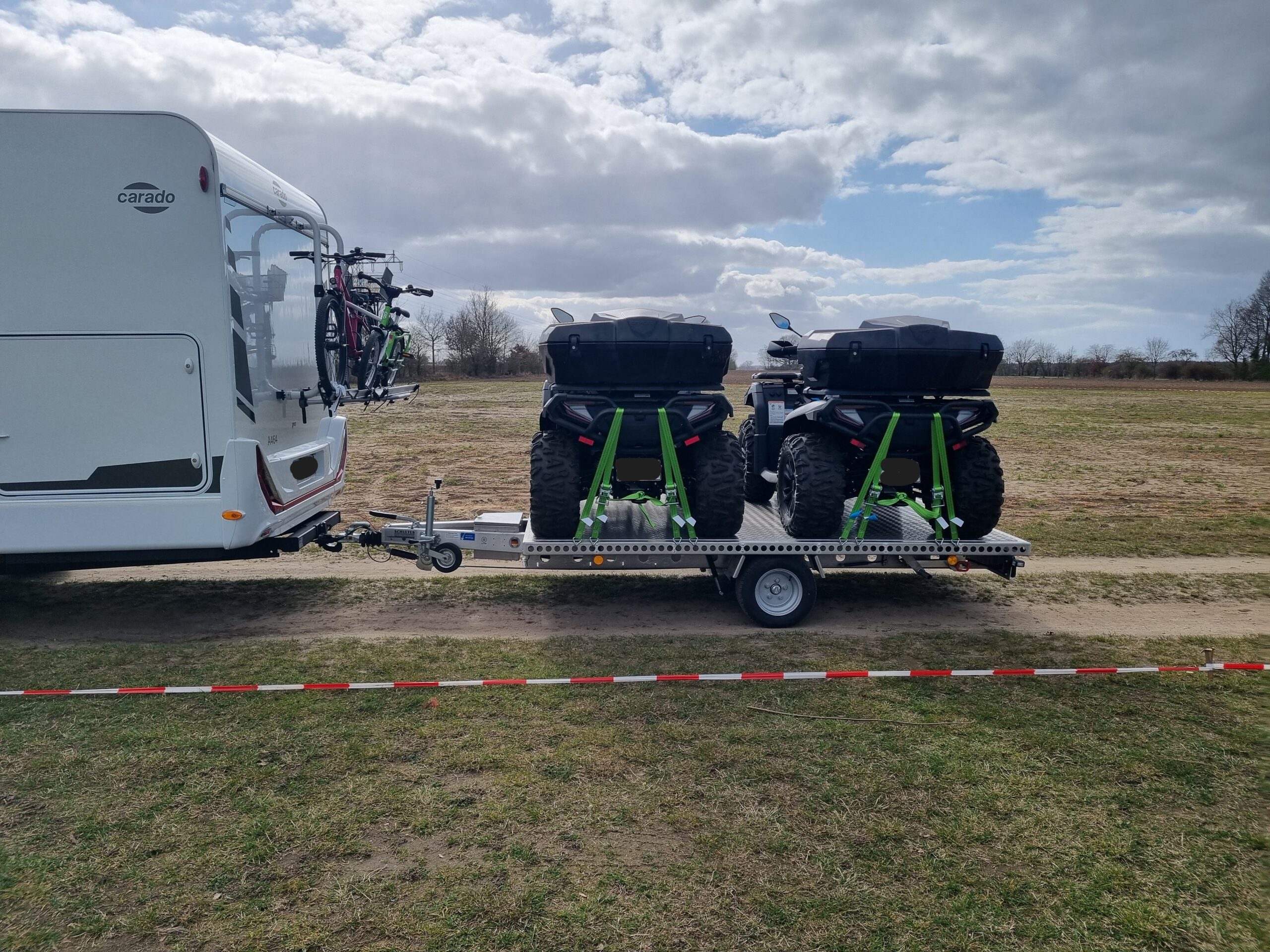 Aluminium Anhänger mit zwei Quad beladen an einem Wohnmobil auf einer Wiese