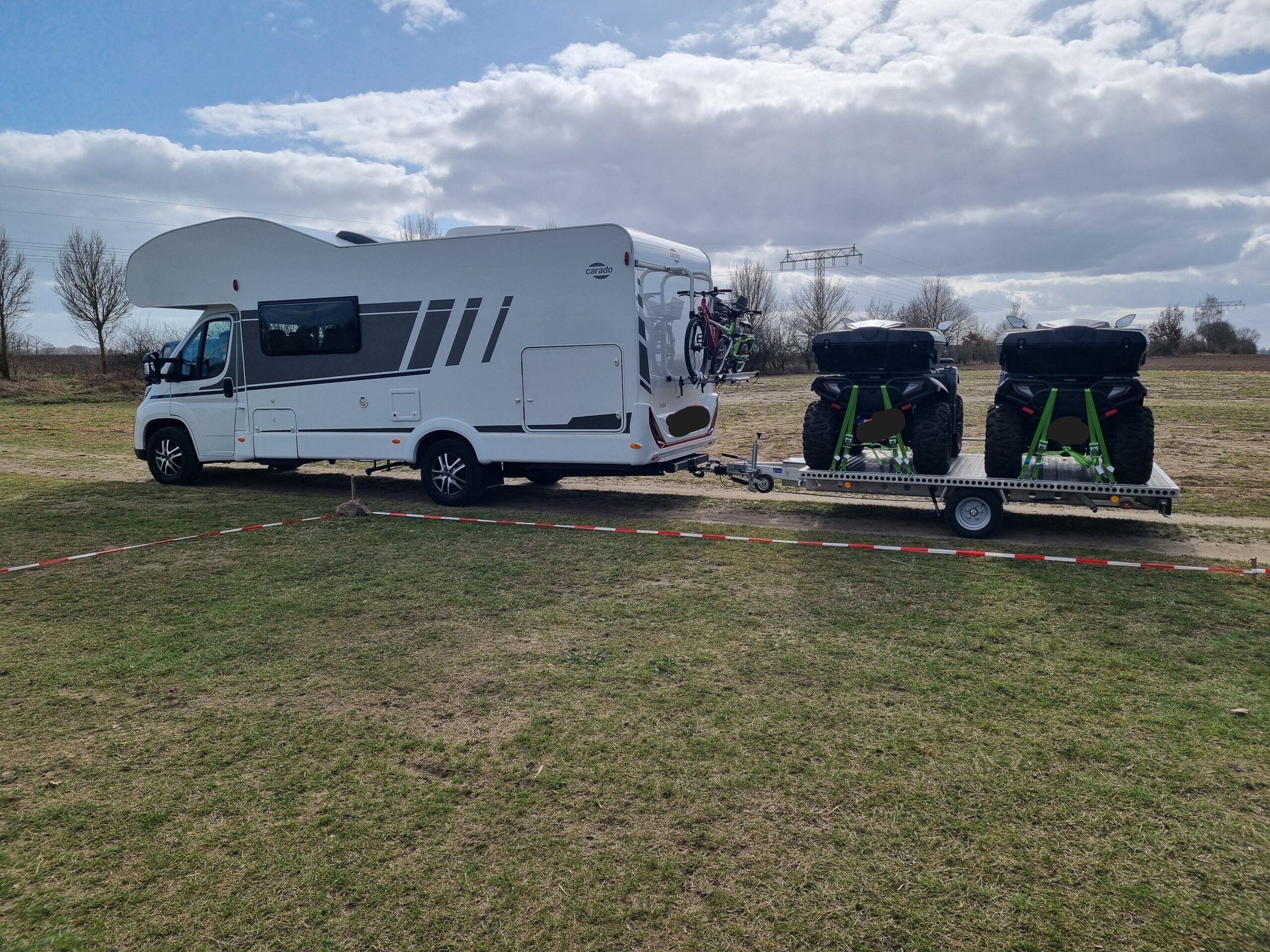 Aluminium Anhänger mit zwei Quad beladen an einem Wohnmobil auf einer Wiese